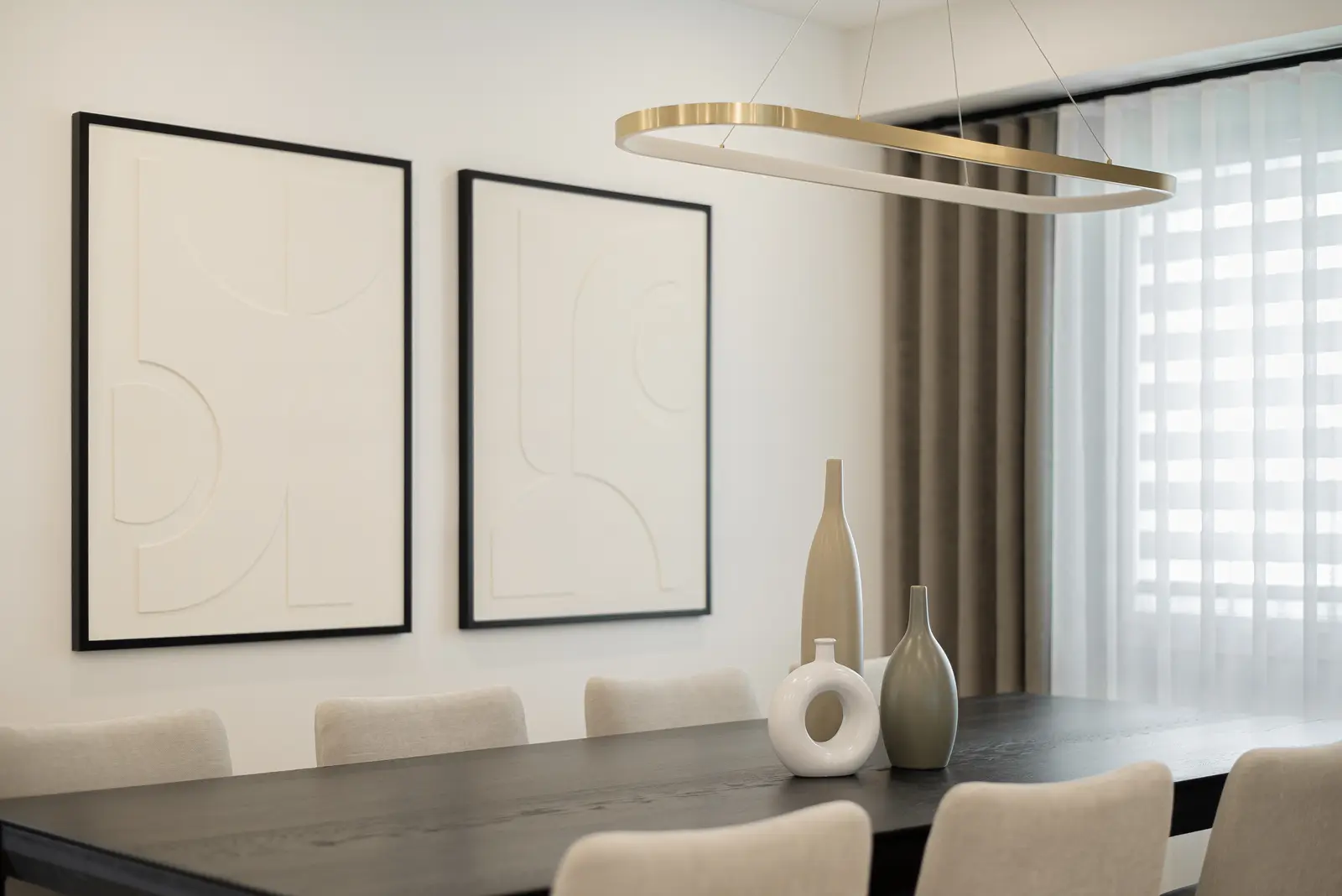 Interior of a Thornhill house renovation, with pale walls, a veined stone kitchen, light wood floors, and black fittings.