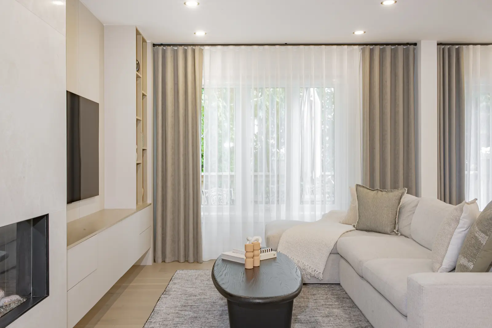 Interior of a Thornhill house renovation, with pale walls, a veined stone kitchen, light wood floors, and black fittings.