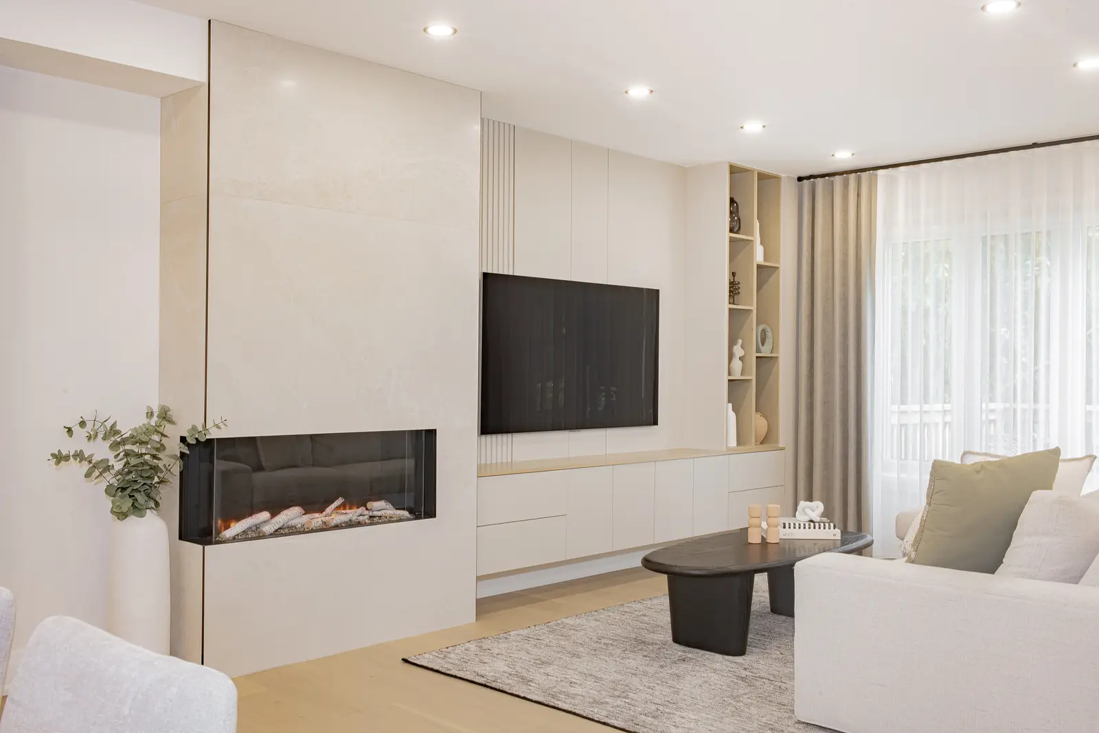 Interior of a Thornhill house renovation, with pale walls, a veined stone kitchen, light wood floors, and black fittings.
