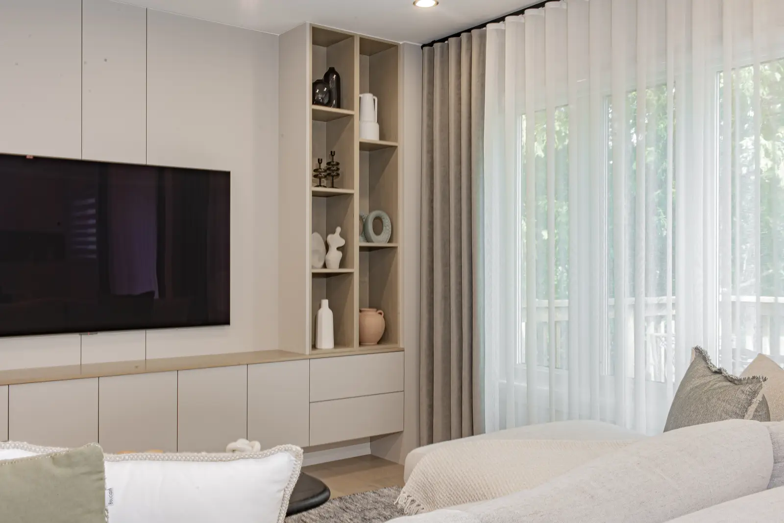 Interior of a Thornhill house renovation, with pale walls, a veined stone kitchen, light wood floors, and black fittings.
