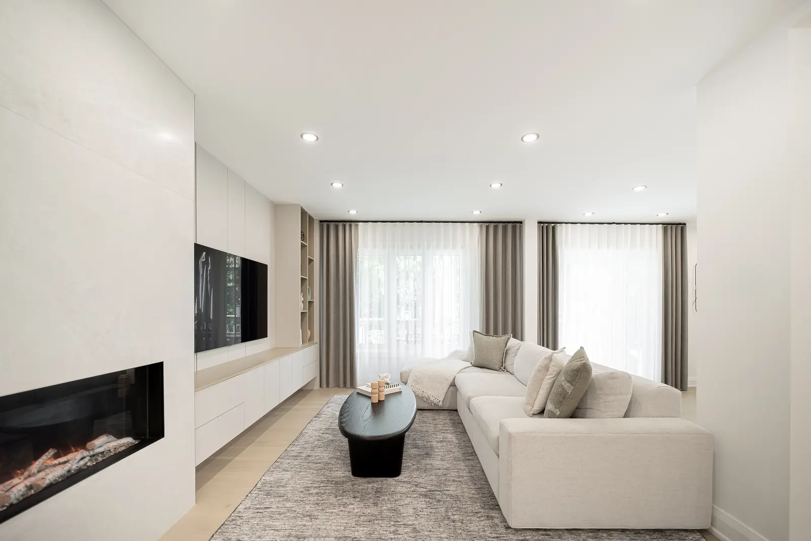Interior of a Thornhill house renovation, with pale walls, a veined stone kitchen, light wood floors, and black fittings.