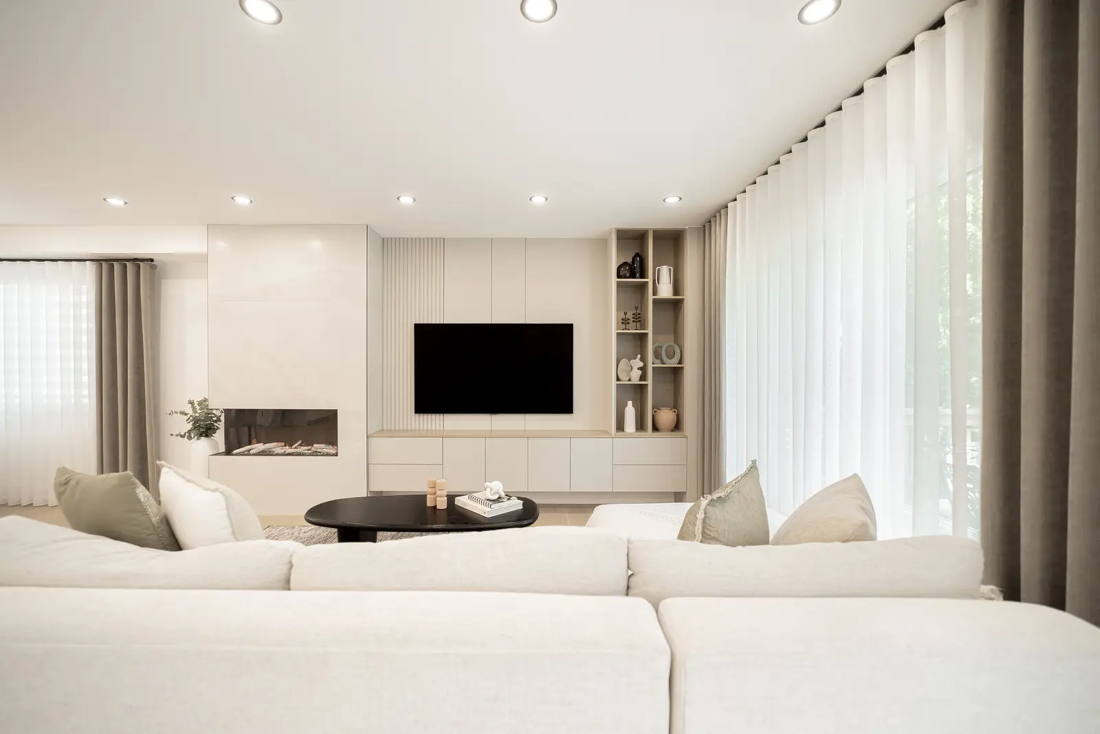 Interior of a Thornhill house renovation, with pale walls, a veined stone kitchen, light wood floors, and black fittings.