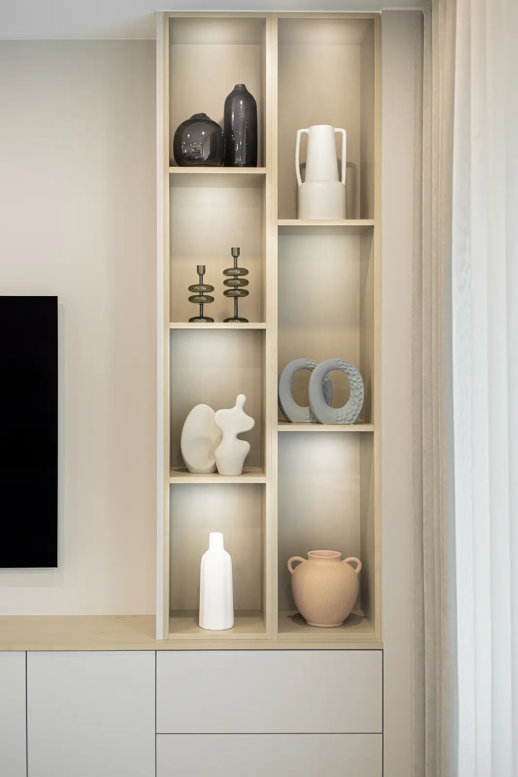 Interior of a Thornhill house renovation, with pale walls, a veined stone kitchen, light wood floors, and black fittings.