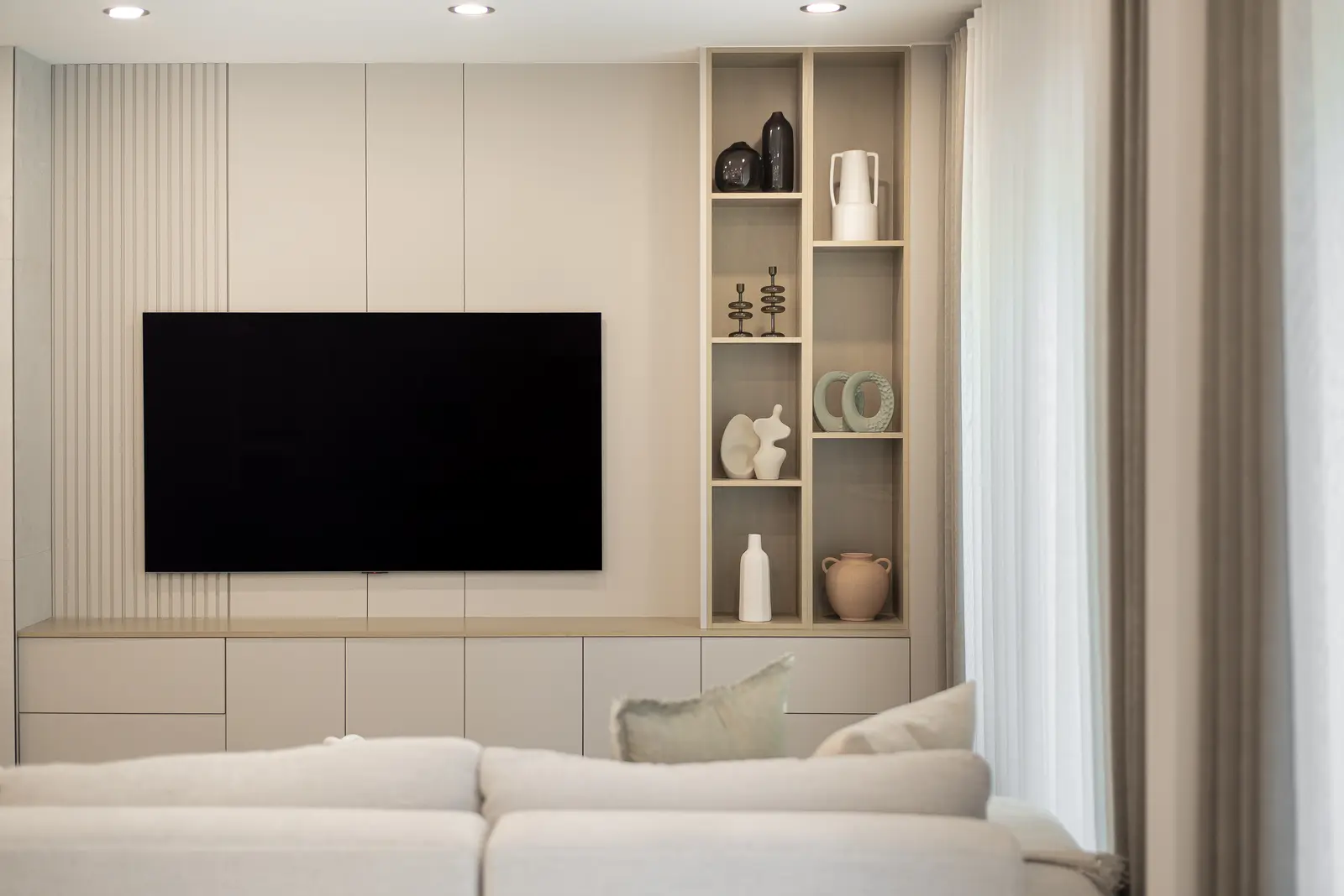 Interior of a Thornhill house renovation, with pale walls, a veined stone kitchen, light wood floors, and black fittings.