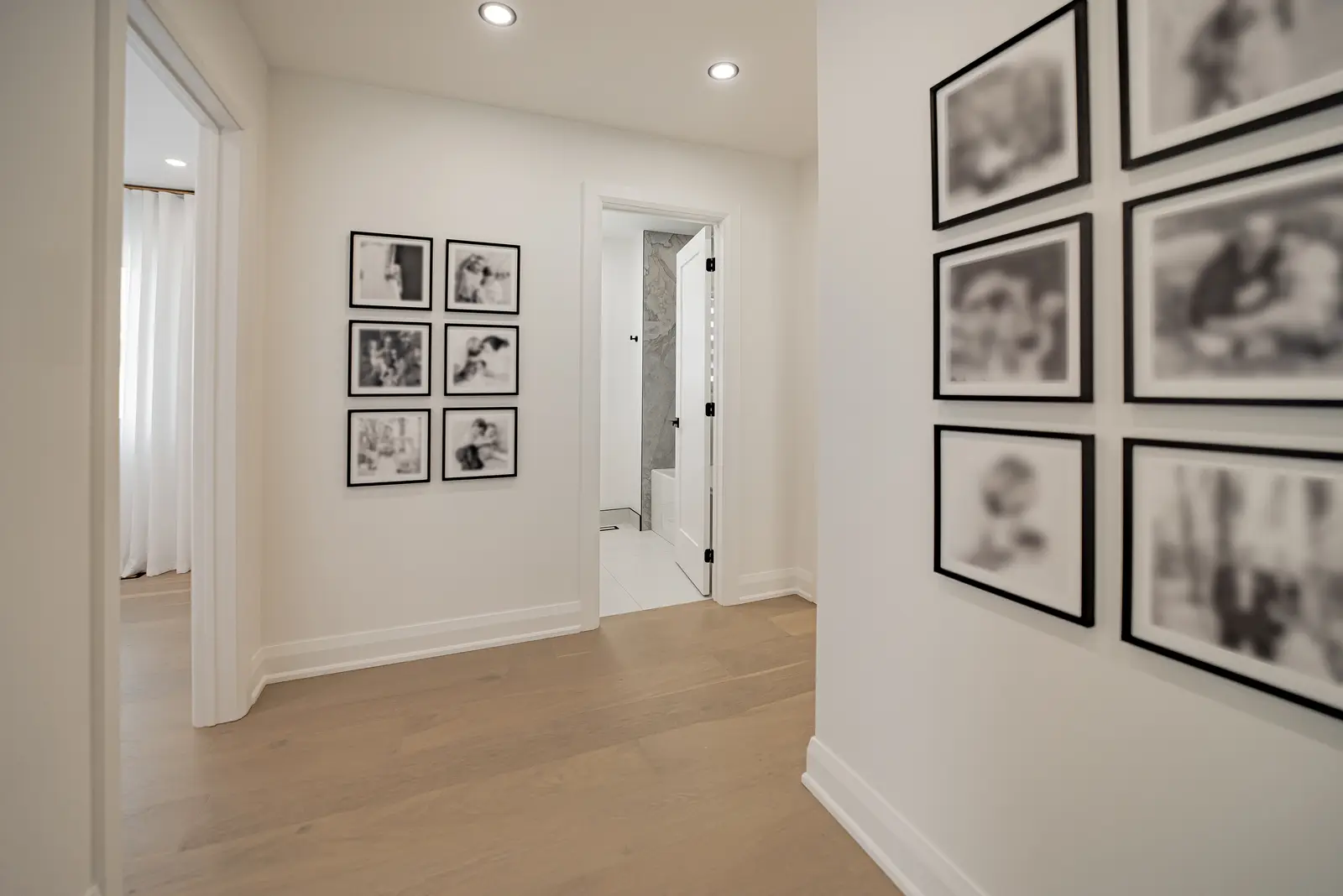 Interior of a Thornhill house renovation, with pale walls, a veined stone kitchen, light wood floors, and black fittings.
