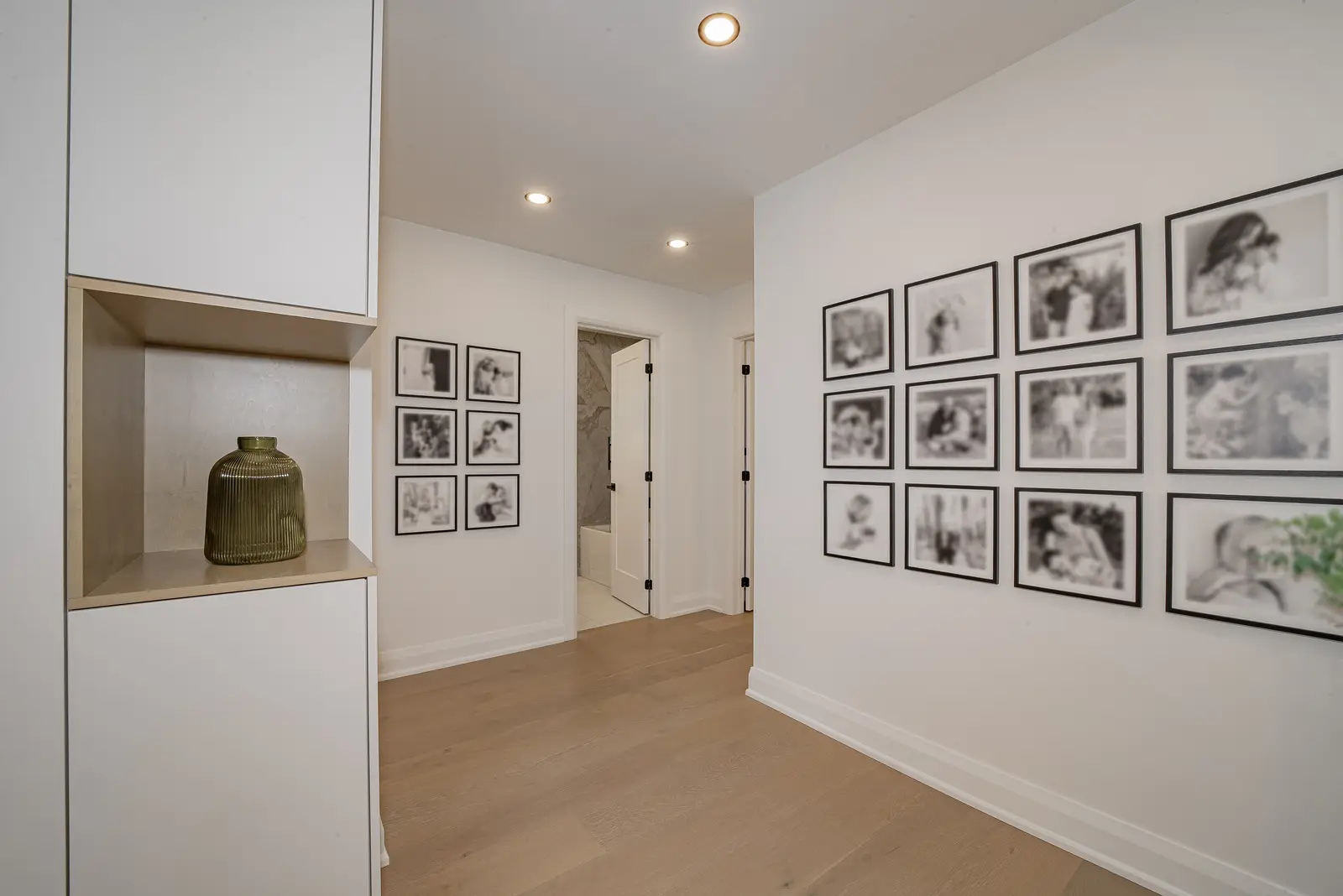Interior of a Thornhill house renovation, with pale walls, a veined stone kitchen, light wood floors, and black fittings.