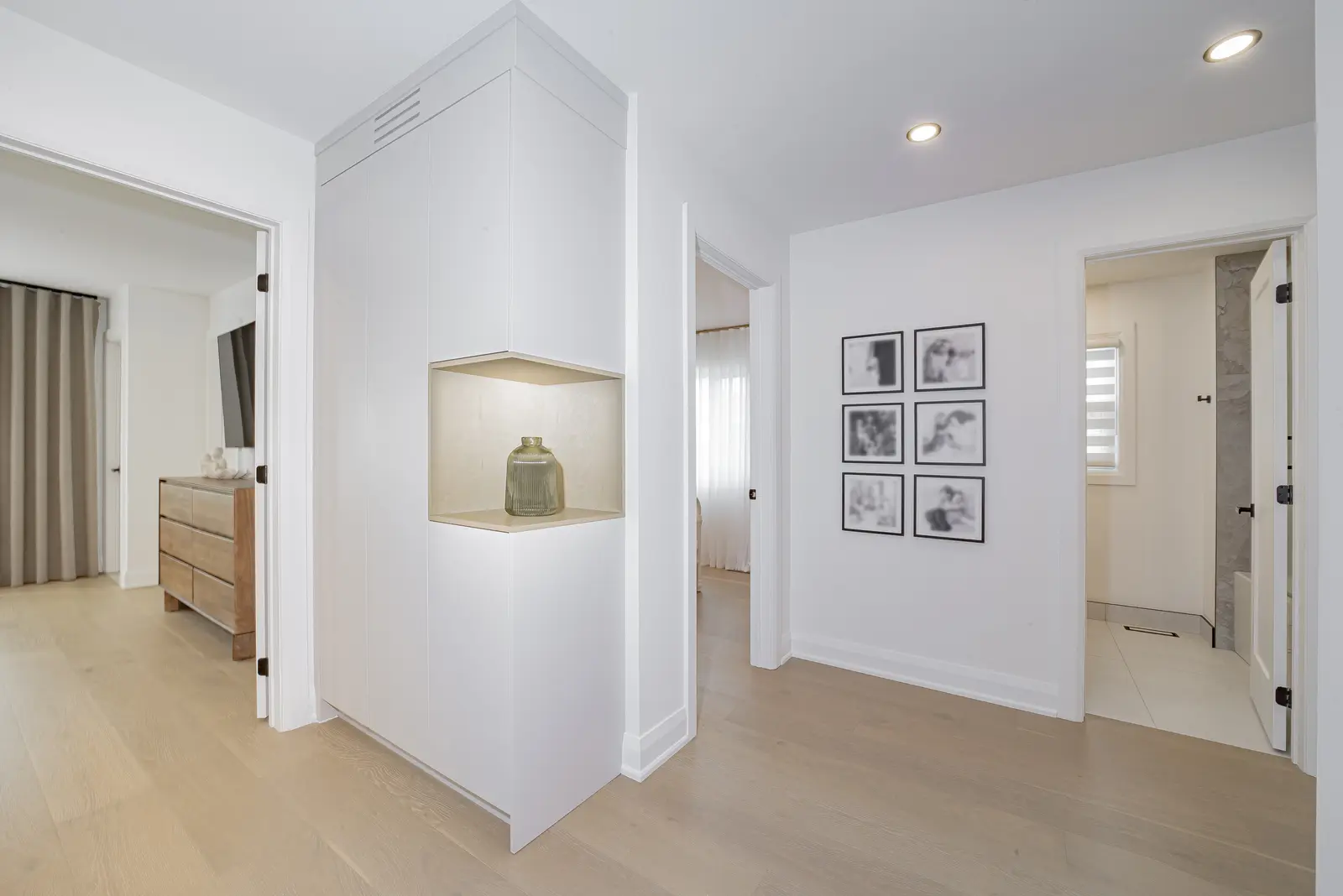 Interior of a Thornhill house renovation, with pale walls, a veined stone kitchen, light wood floors, and black fittings.