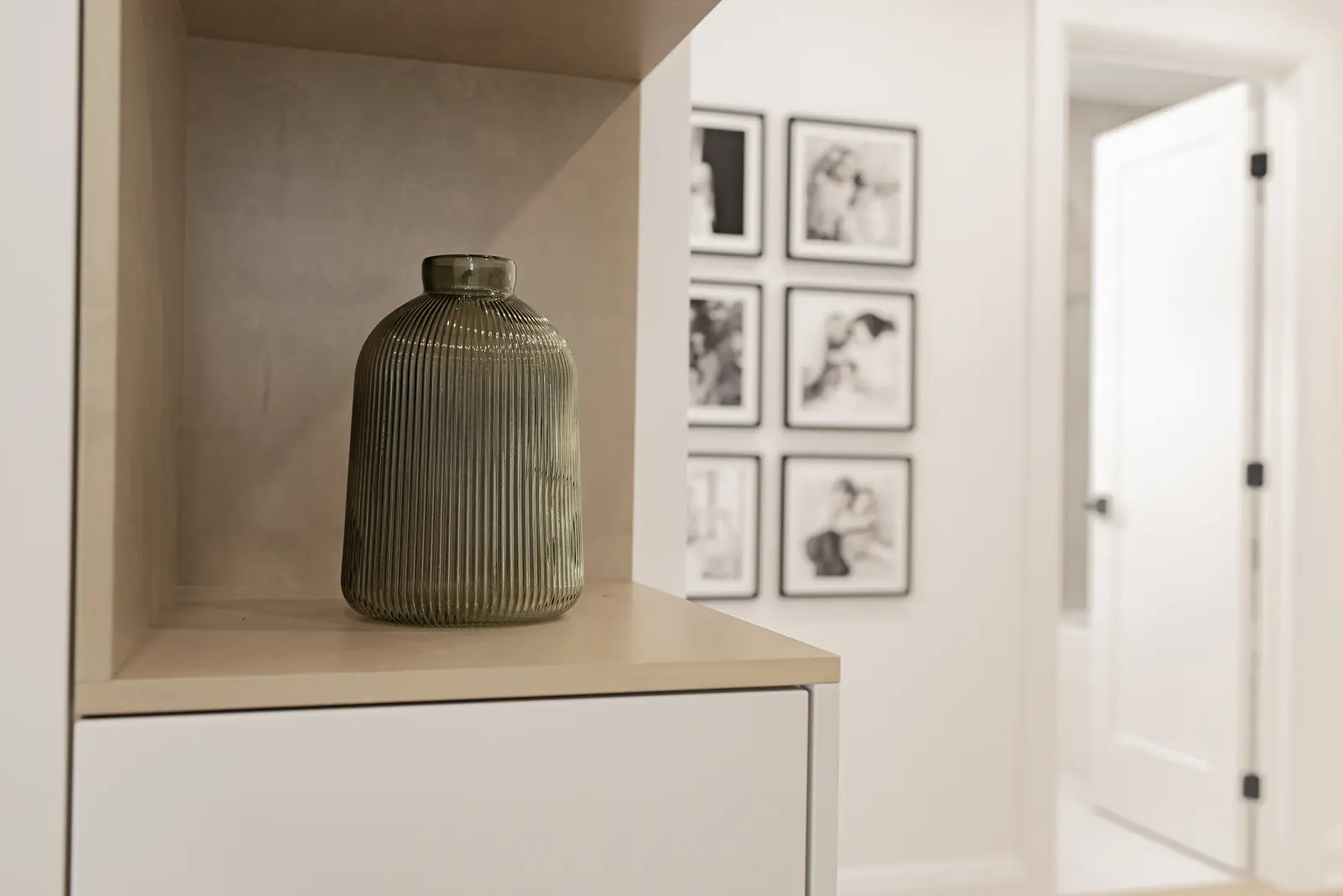 Interior of a Thornhill house renovation, with pale walls, a veined stone kitchen, light wood floors, and black fittings.