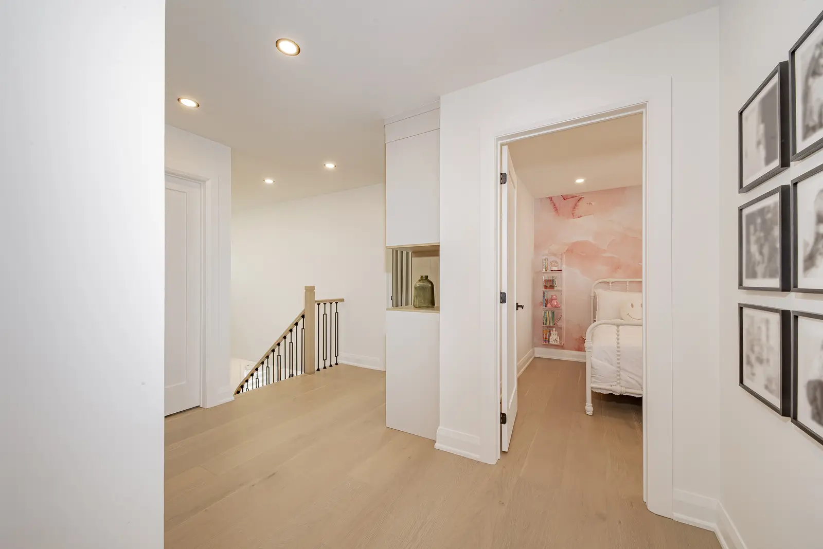 Interior of a Thornhill house renovation, with pale walls, a veined stone kitchen, light wood floors, and black fittings.