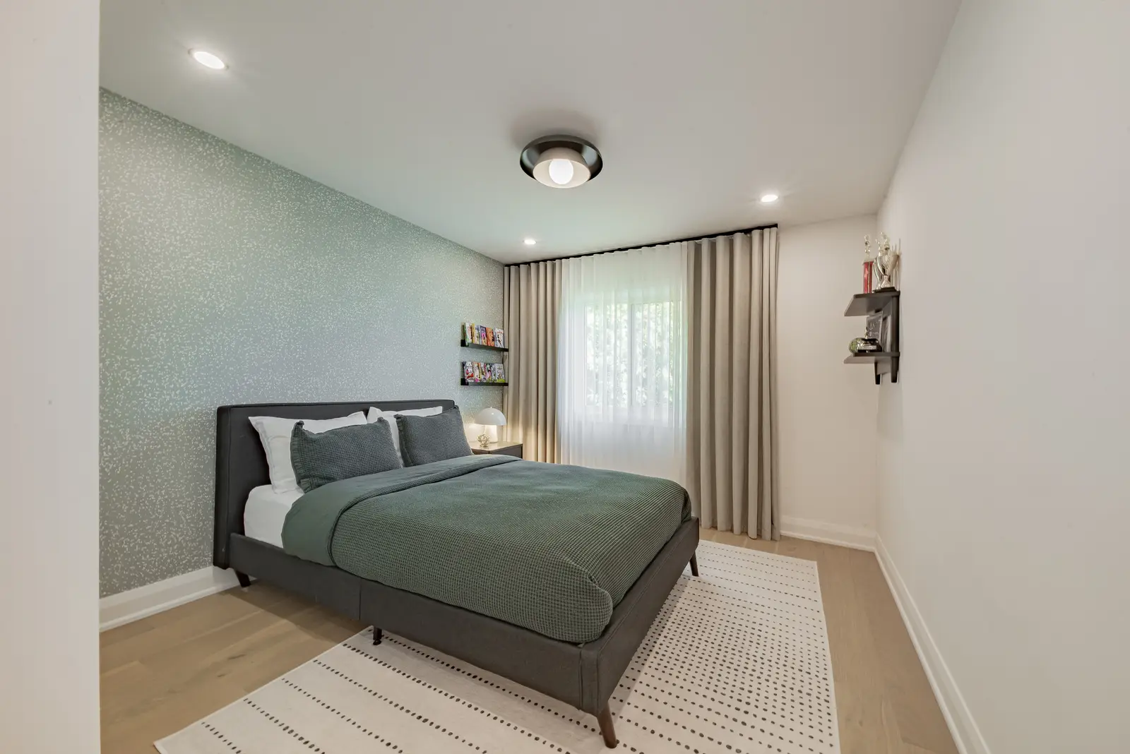 Interior of a Thornhill house renovation, with pale walls, a veined stone kitchen, light wood floors, and black fittings.