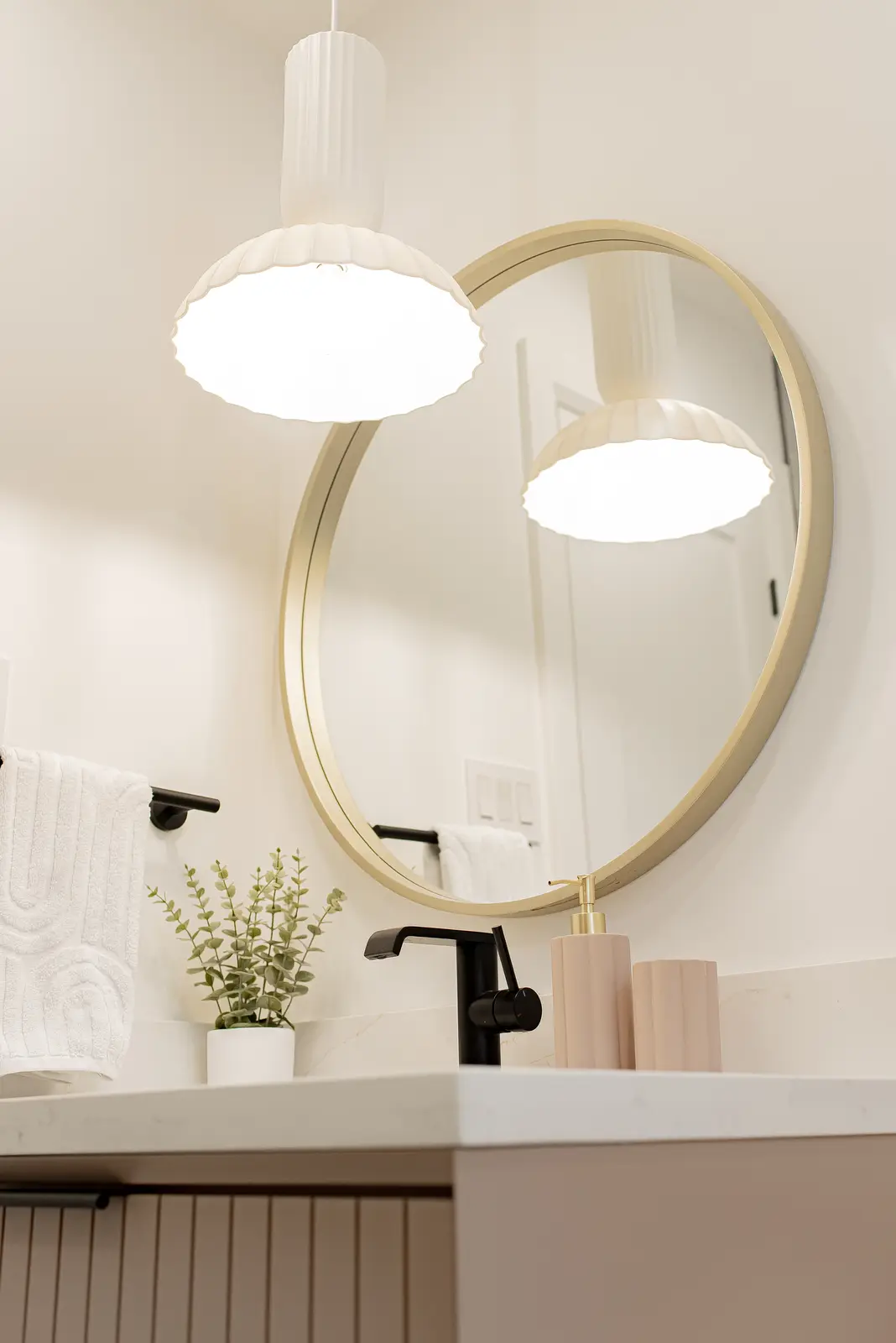 Interior of a Thornhill house renovation, with pale walls, a veined stone kitchen, light wood floors, and black fittings.