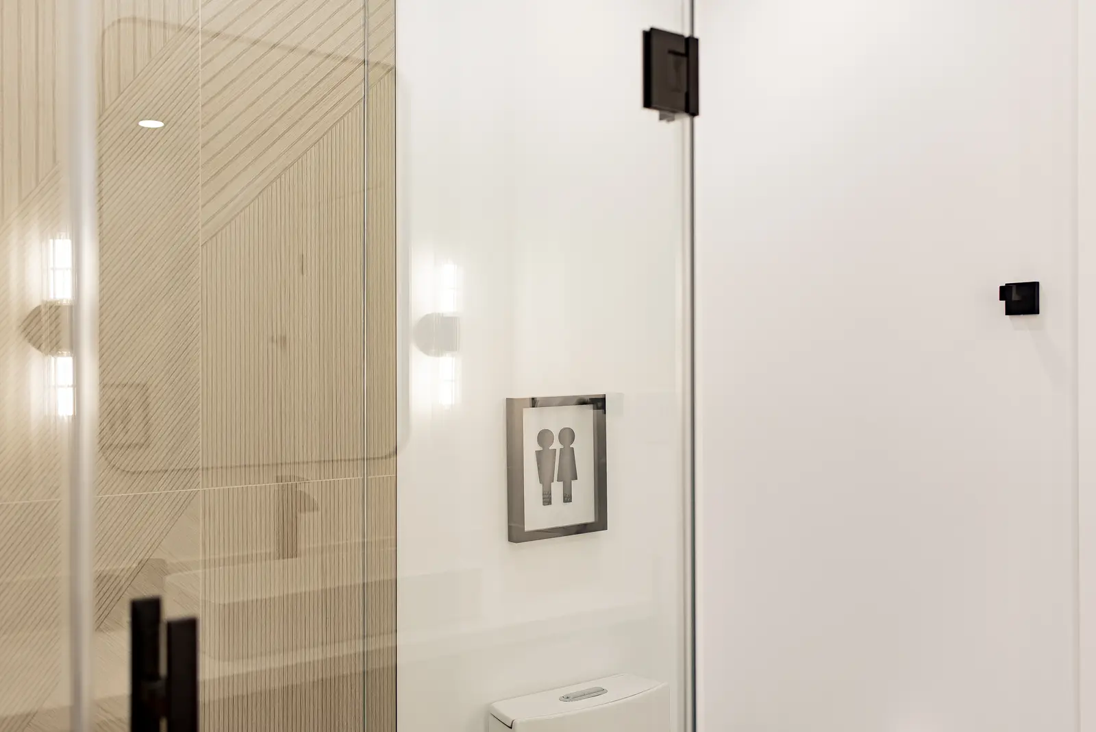 Interior of a Thornhill house renovation, with pale walls, a veined stone kitchen, light wood floors, and black fittings.