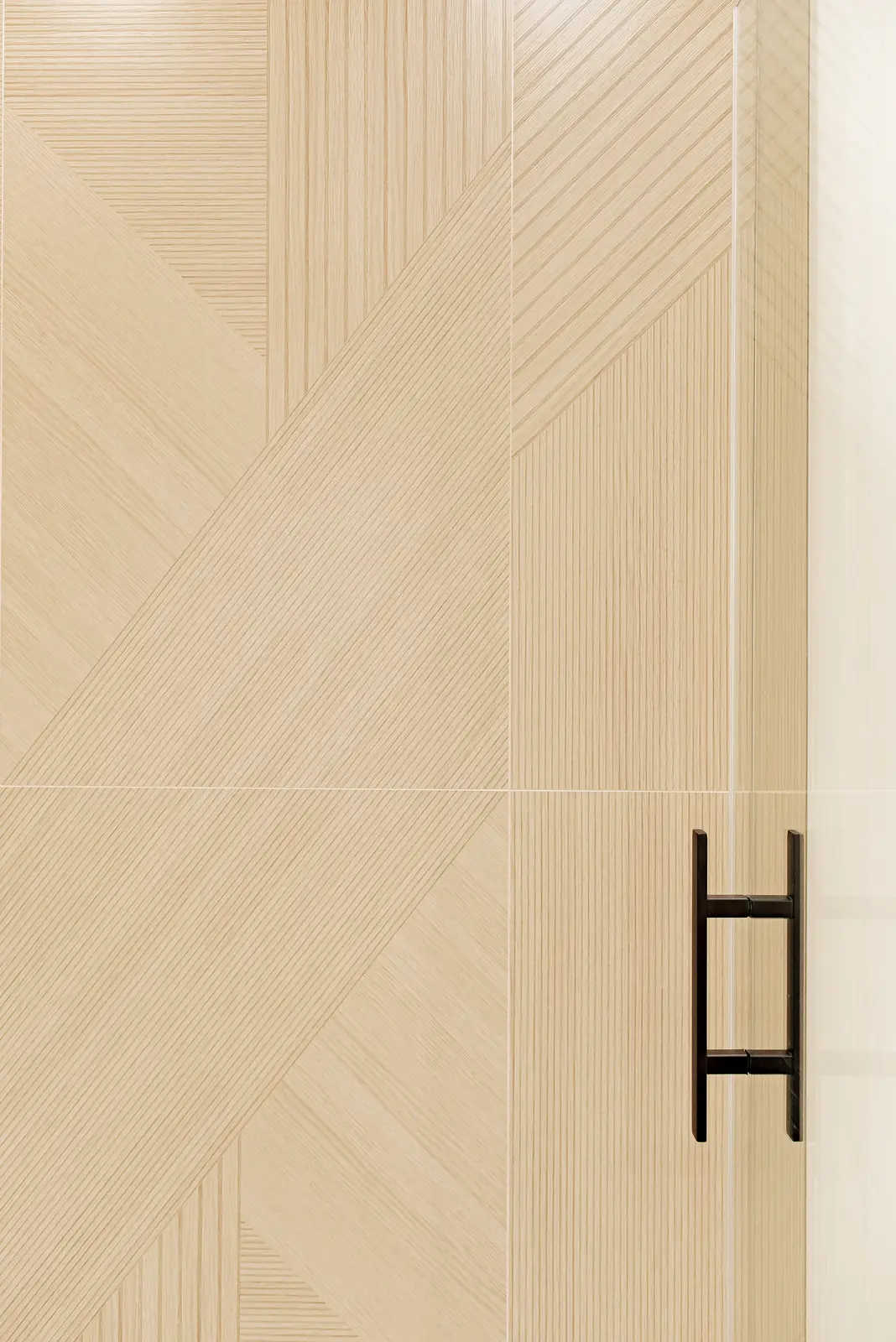 Interior of a Thornhill house renovation, with pale walls, a veined stone kitchen, light wood floors, and black fittings.