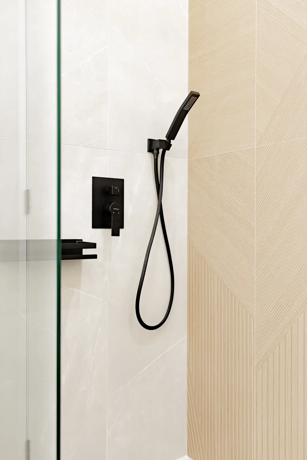 Interior of a Thornhill house renovation, with pale walls, a veined stone kitchen, light wood floors, and black fittings.