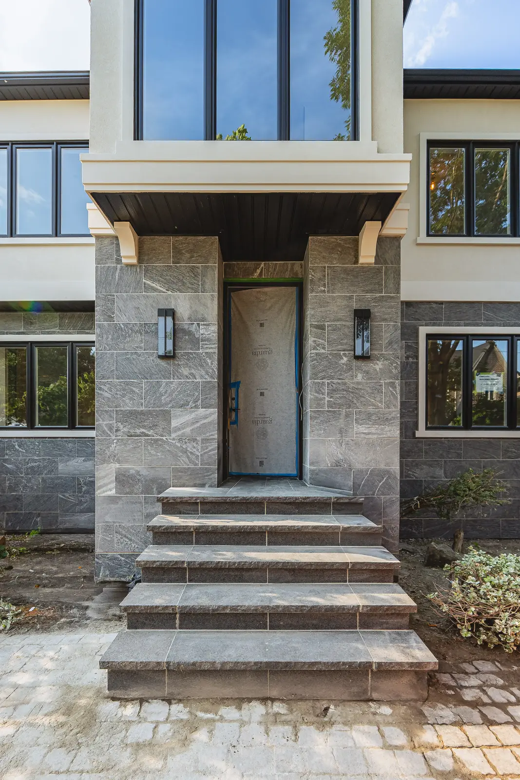 Room in a North York detached house renovation, with pale oak floors, white walls, and marble or warm wood millwork.