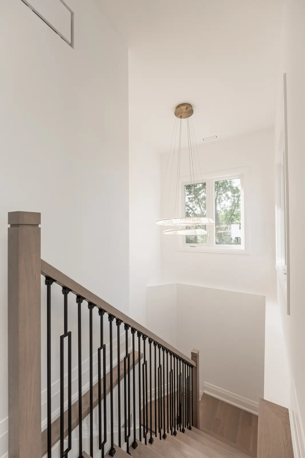 Room in a North York detached house renovation, with pale oak floors, white walls, and marble or warm wood millwork.