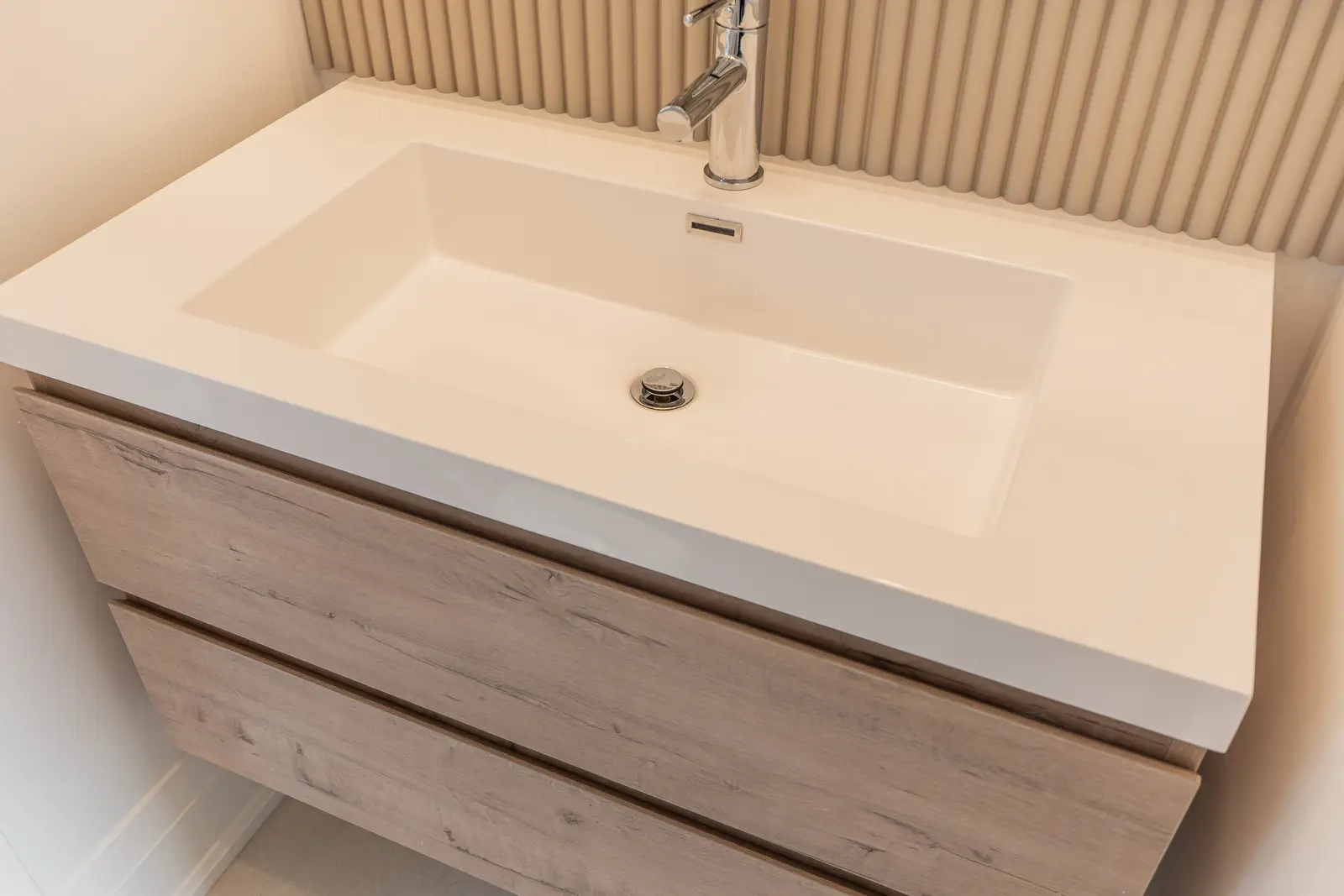 Room in a North York detached house renovation, with pale oak floors, white walls, and marble or warm wood millwork.