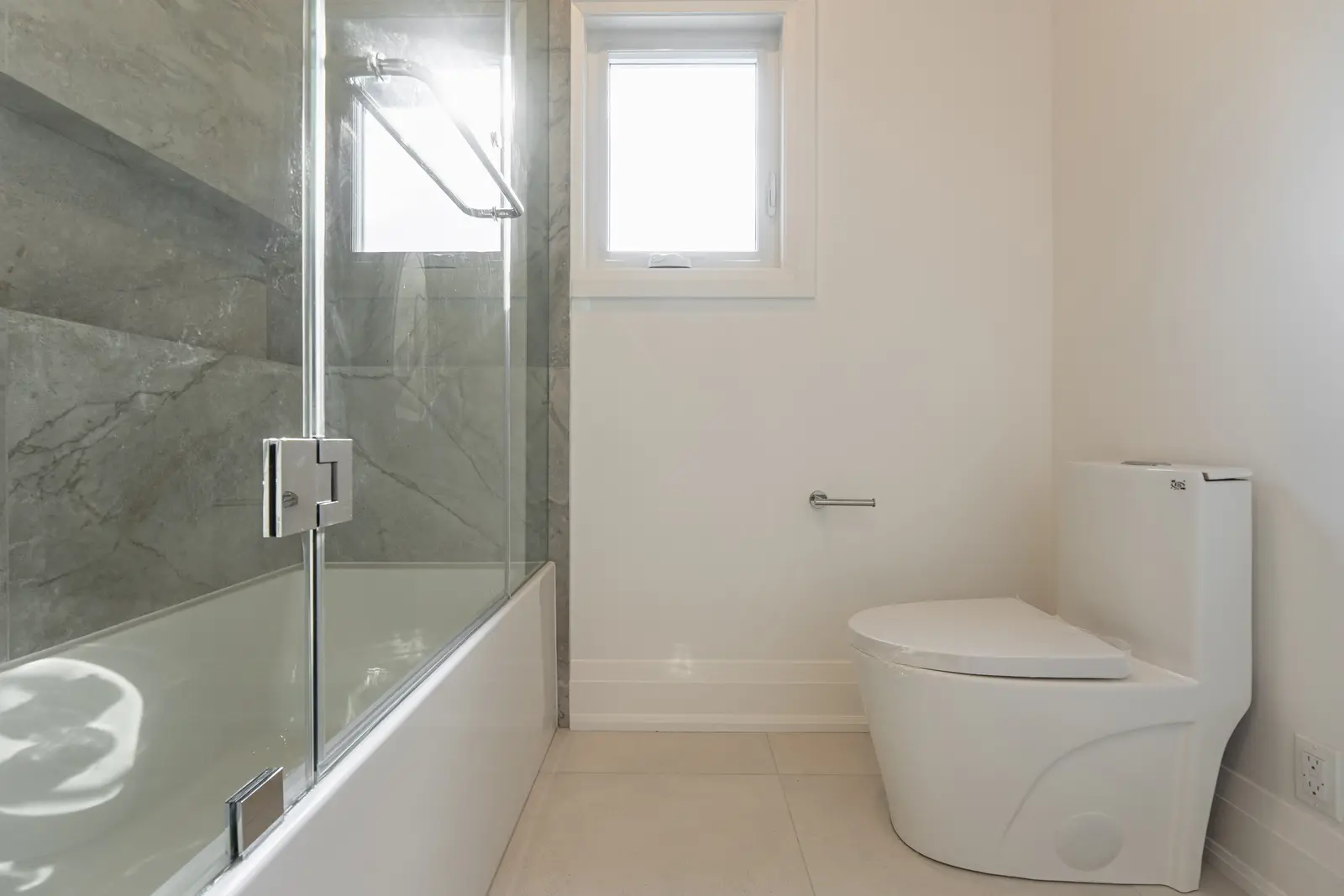 Room in a North York detached house renovation, with pale oak floors, white walls, and marble or warm wood millwork.