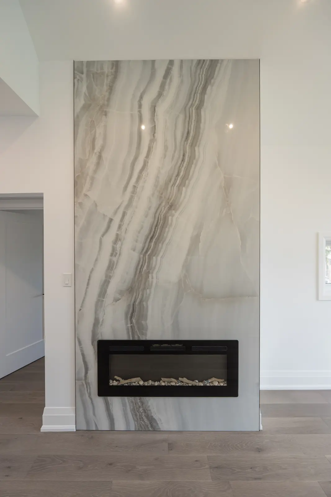 Room in a North York detached house renovation, with pale oak floors, white walls, and marble or warm wood millwork.