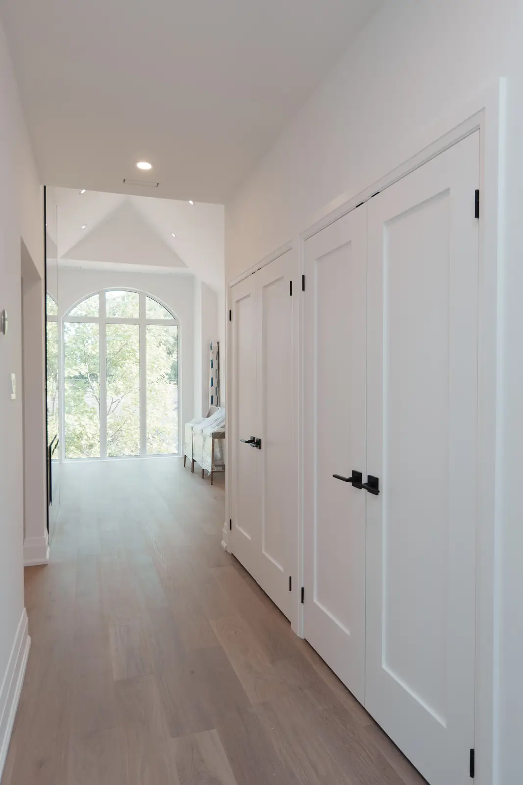 Room in a North York detached house renovation, with pale oak floors, white walls, and marble or warm wood millwork.