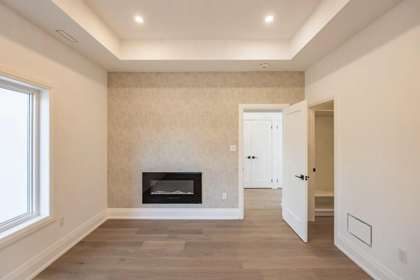 Room in a North York detached house renovation, with pale oak floors, white walls, and marble or warm wood millwork.