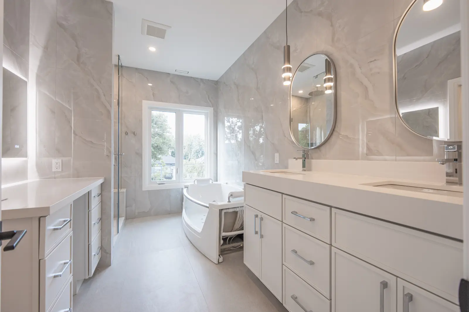 Room in a North York detached house renovation, with pale oak floors, white walls, and marble or warm wood millwork.