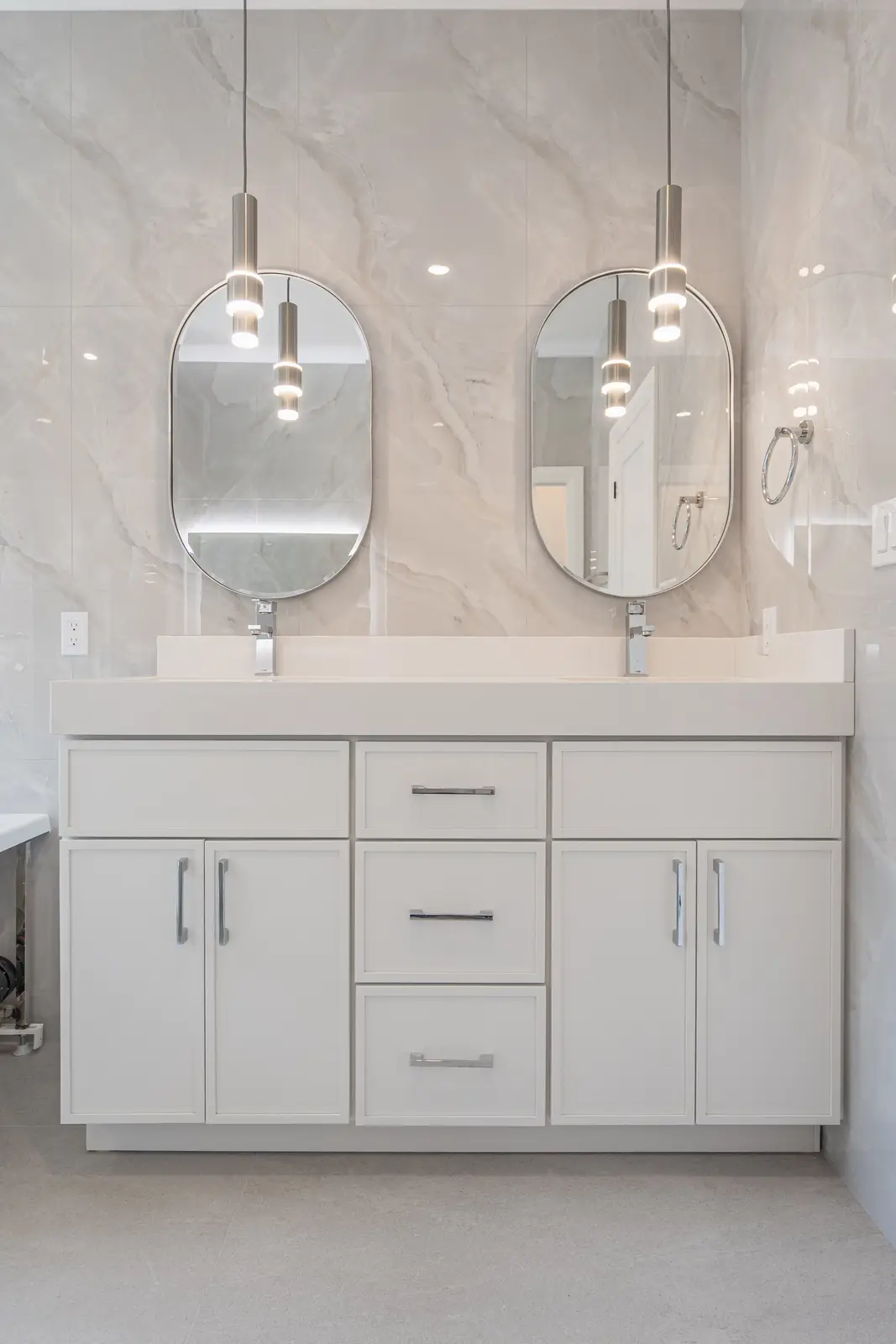 Room in a North York detached house renovation, with pale oak floors, white walls, and marble or warm wood millwork.