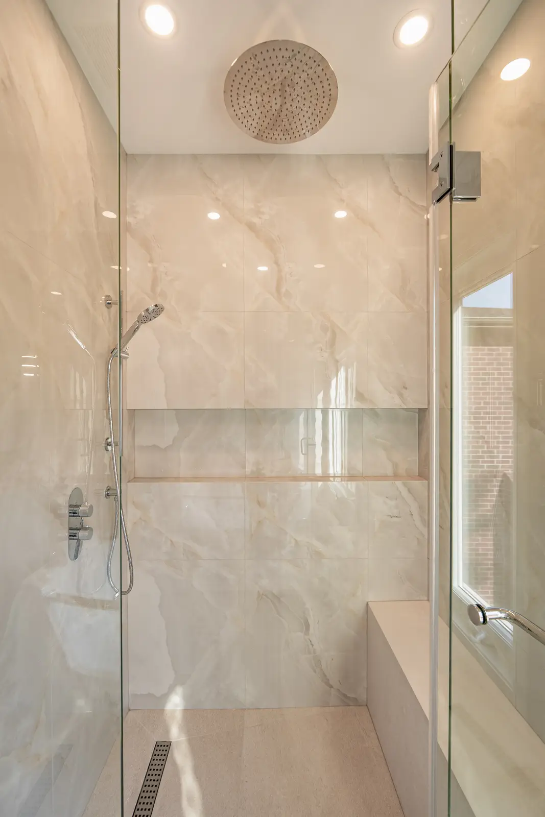 Room in a North York detached house renovation, with pale oak floors, white walls, and marble or warm wood millwork.