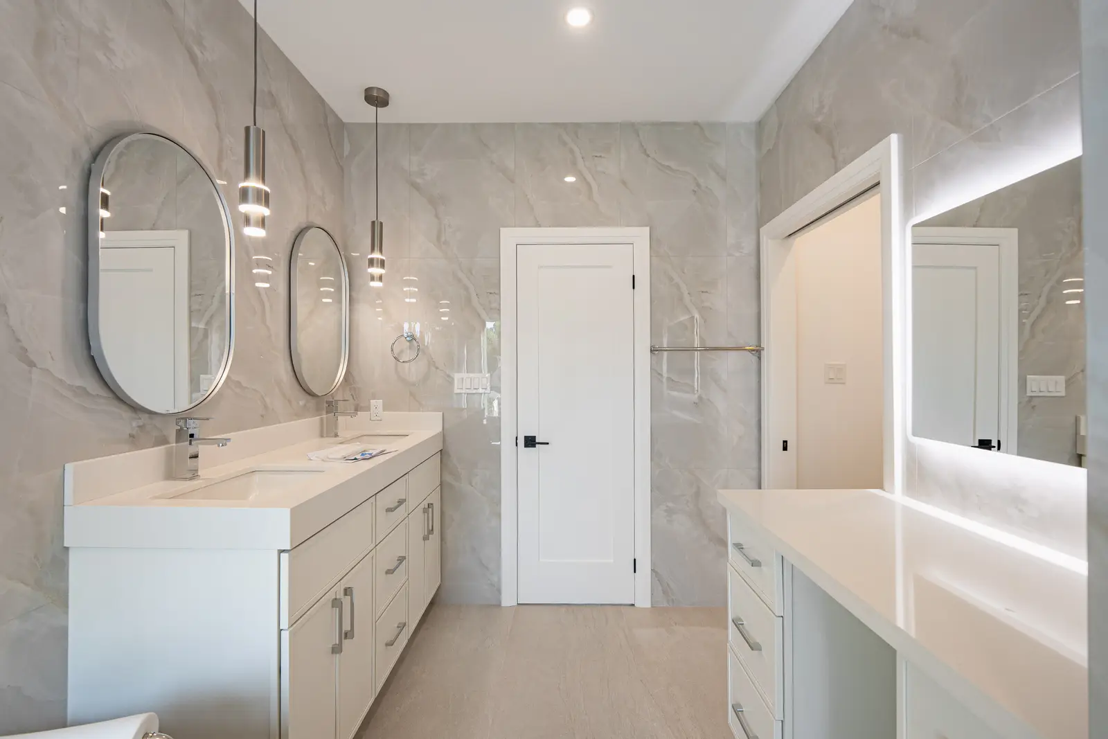 Room in a North York detached house renovation, with pale oak floors, white walls, and marble or warm wood millwork.