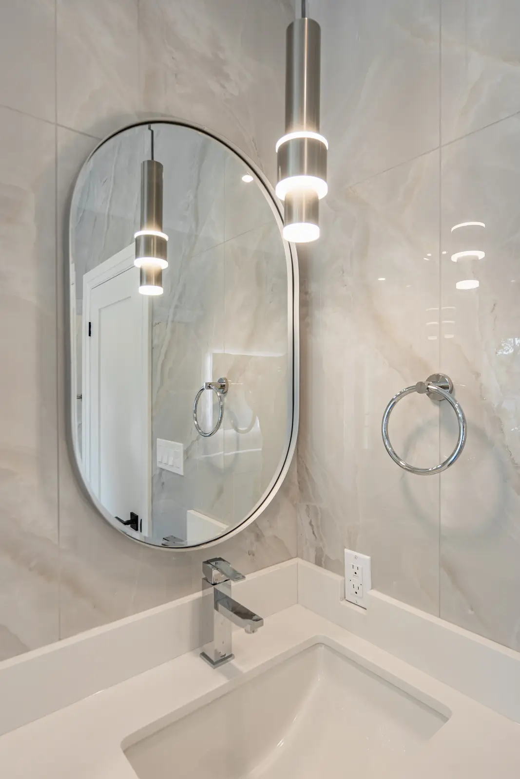 Room in a North York detached house renovation, with pale oak floors, white walls, and marble or warm wood millwork.