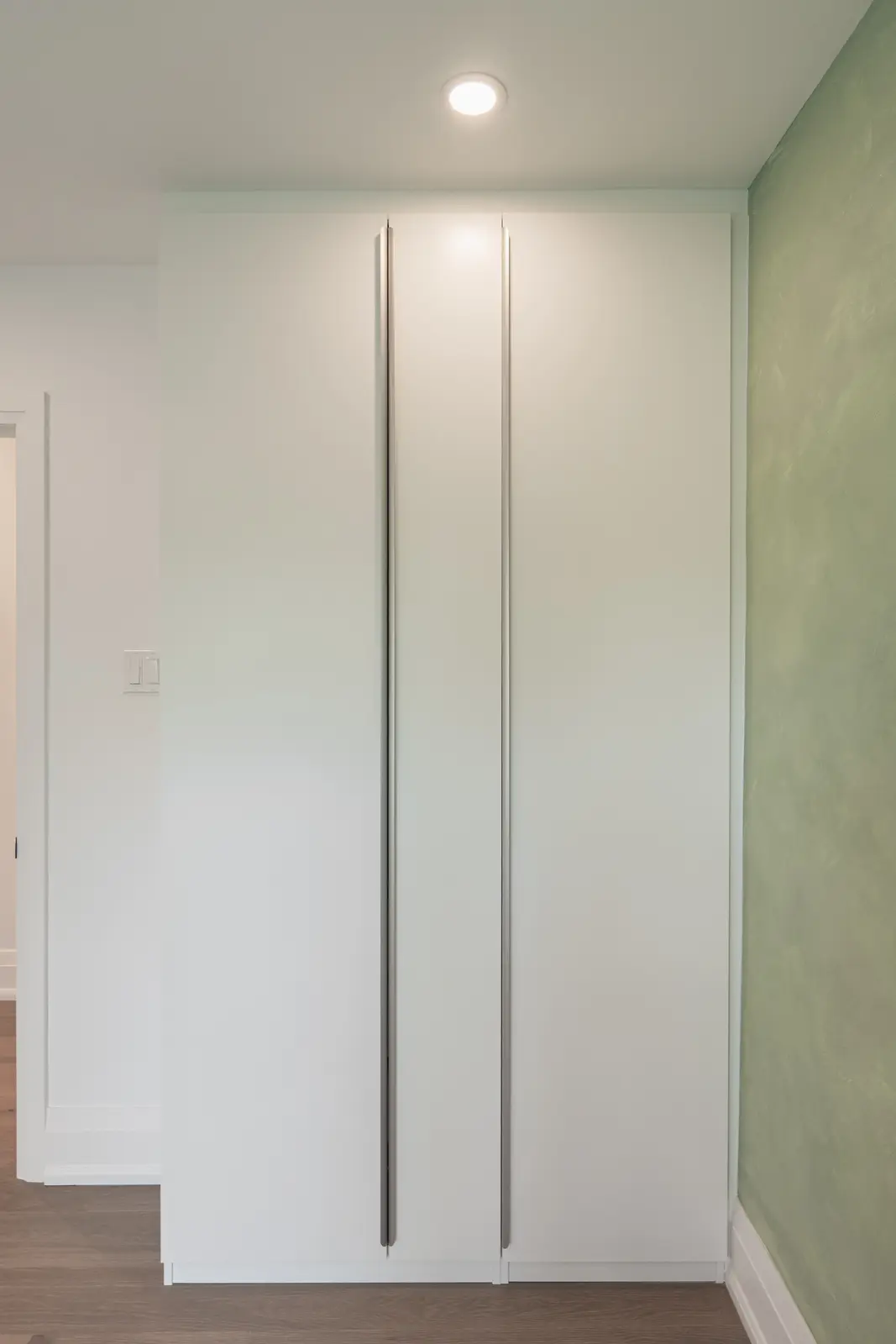 Room in a North York detached house renovation, with pale oak floors, white walls, and marble or warm wood millwork.