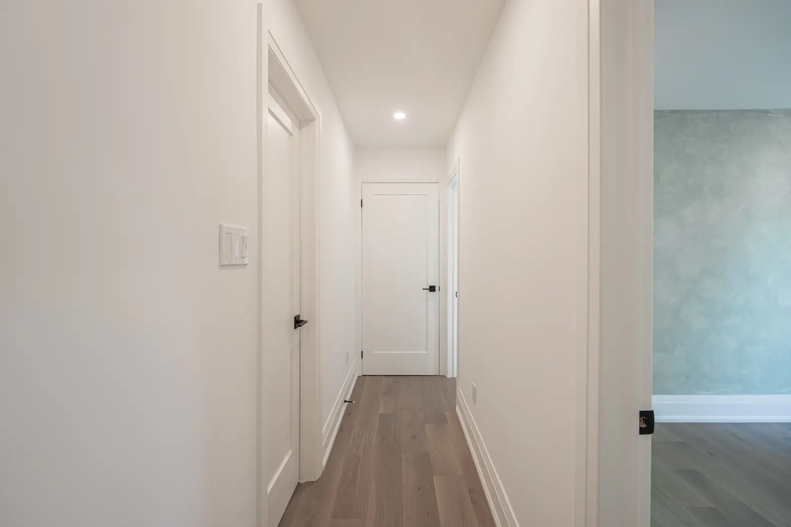 Room in a North York detached house renovation, with pale oak floors, white walls, and marble or warm wood millwork.