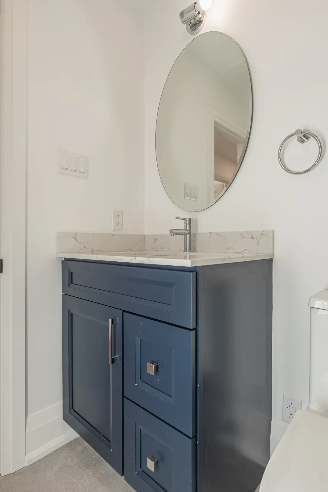 Room in a North York detached house renovation, with pale oak floors, white walls, and marble or warm wood millwork.