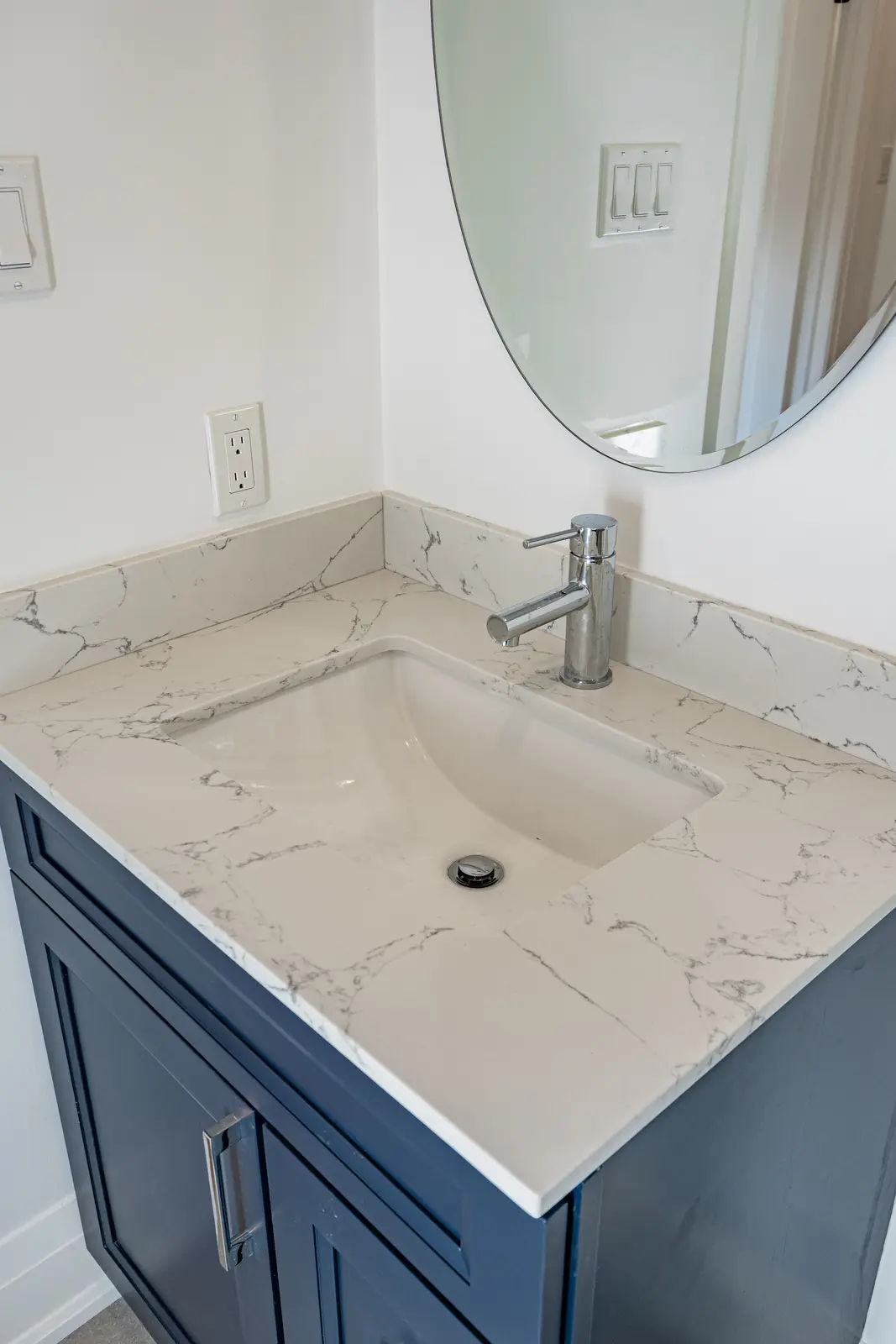 Room in a North York detached house renovation, with pale oak floors, white walls, and marble or warm wood millwork.