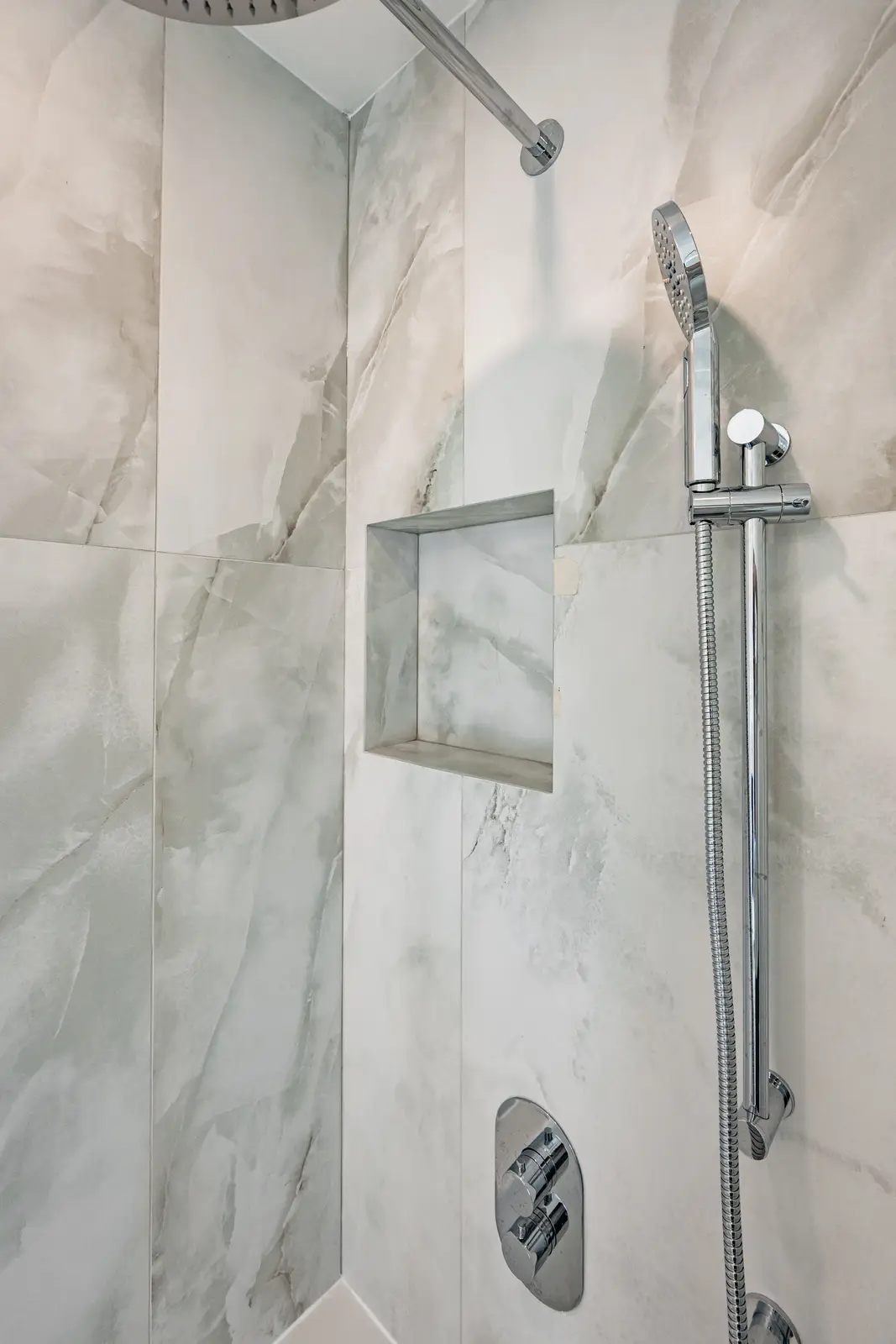 Room in a North York detached house renovation, with pale oak floors, white walls, and marble or warm wood millwork.