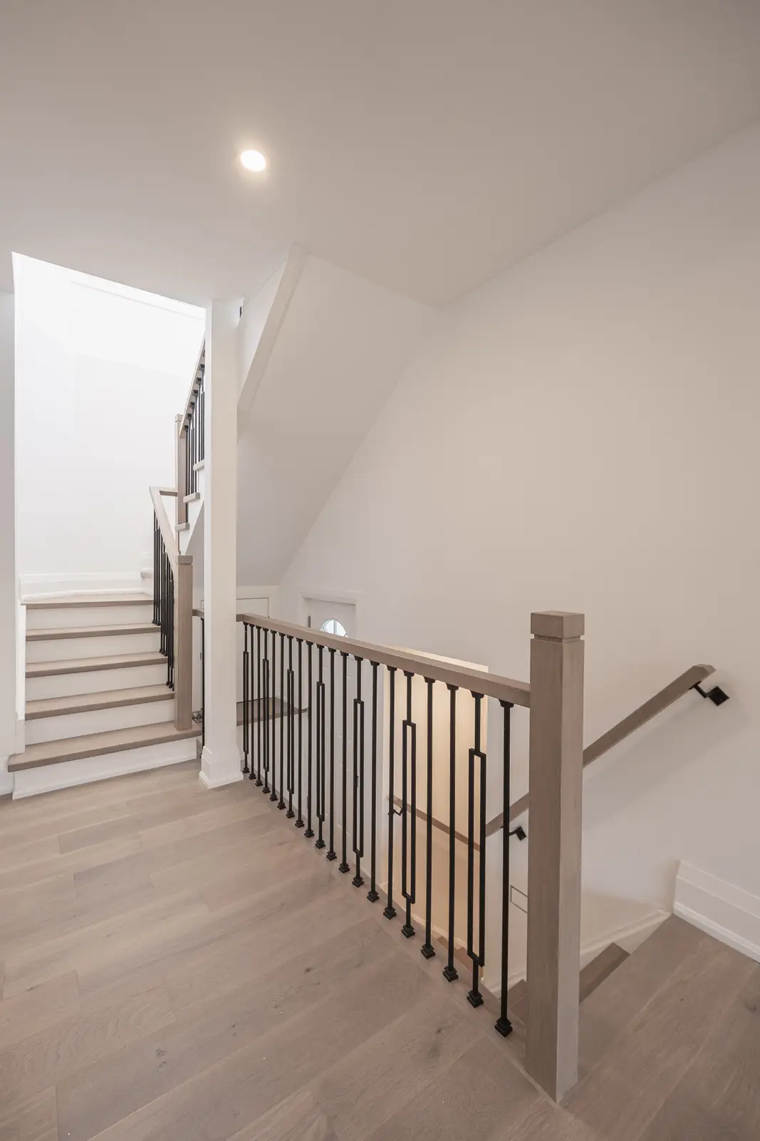Room in a North York detached house renovation, with pale oak floors, white walls, and marble or warm wood millwork.