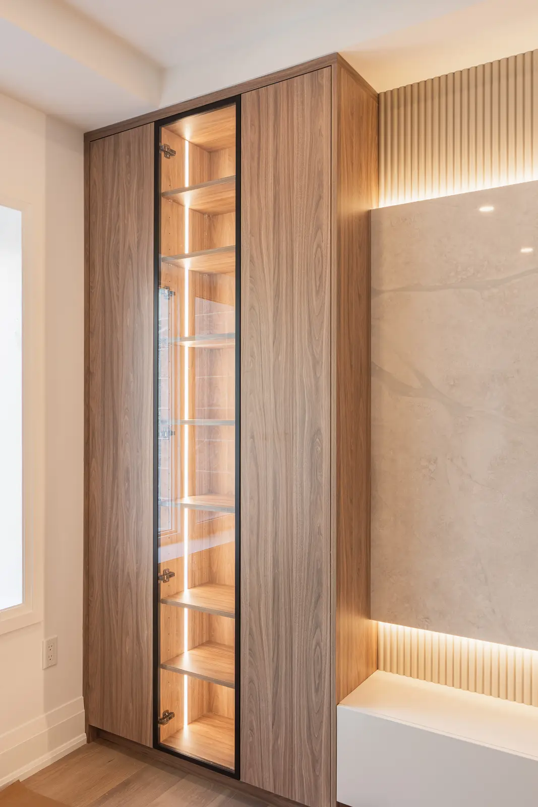 Room in a North York detached house renovation, with pale oak floors, white walls, and marble or warm wood millwork.