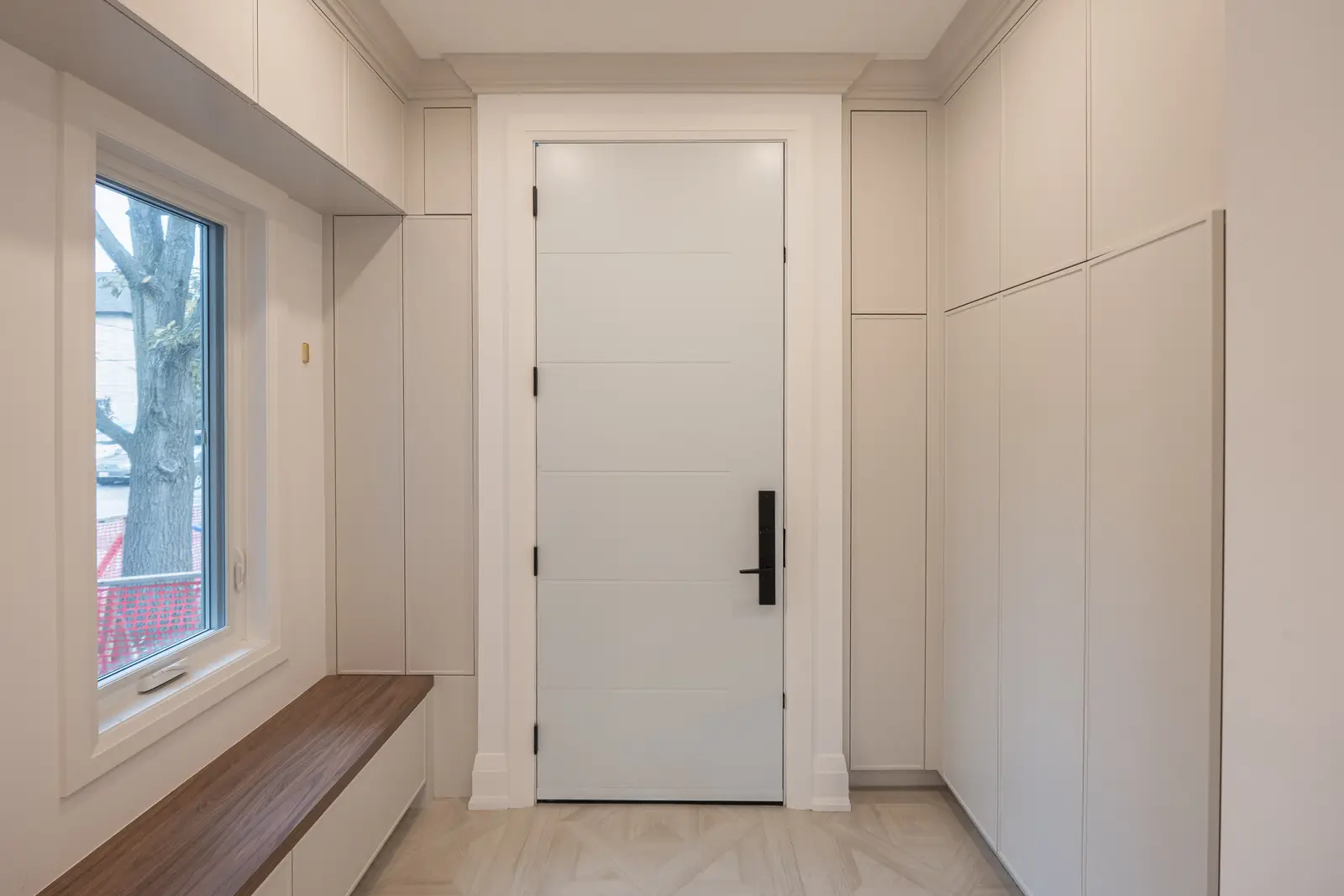 Room in a North York detached house renovation, with pale oak floors, white walls, and marble or warm wood millwork.