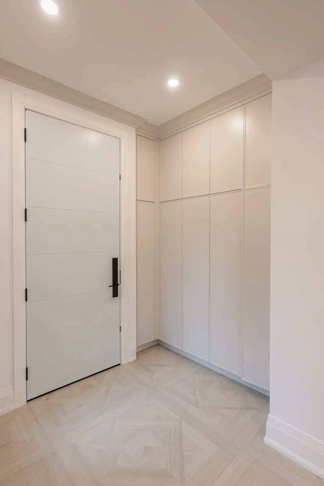 Room in a North York detached house renovation, with pale oak floors, white walls, and marble or warm wood millwork.
