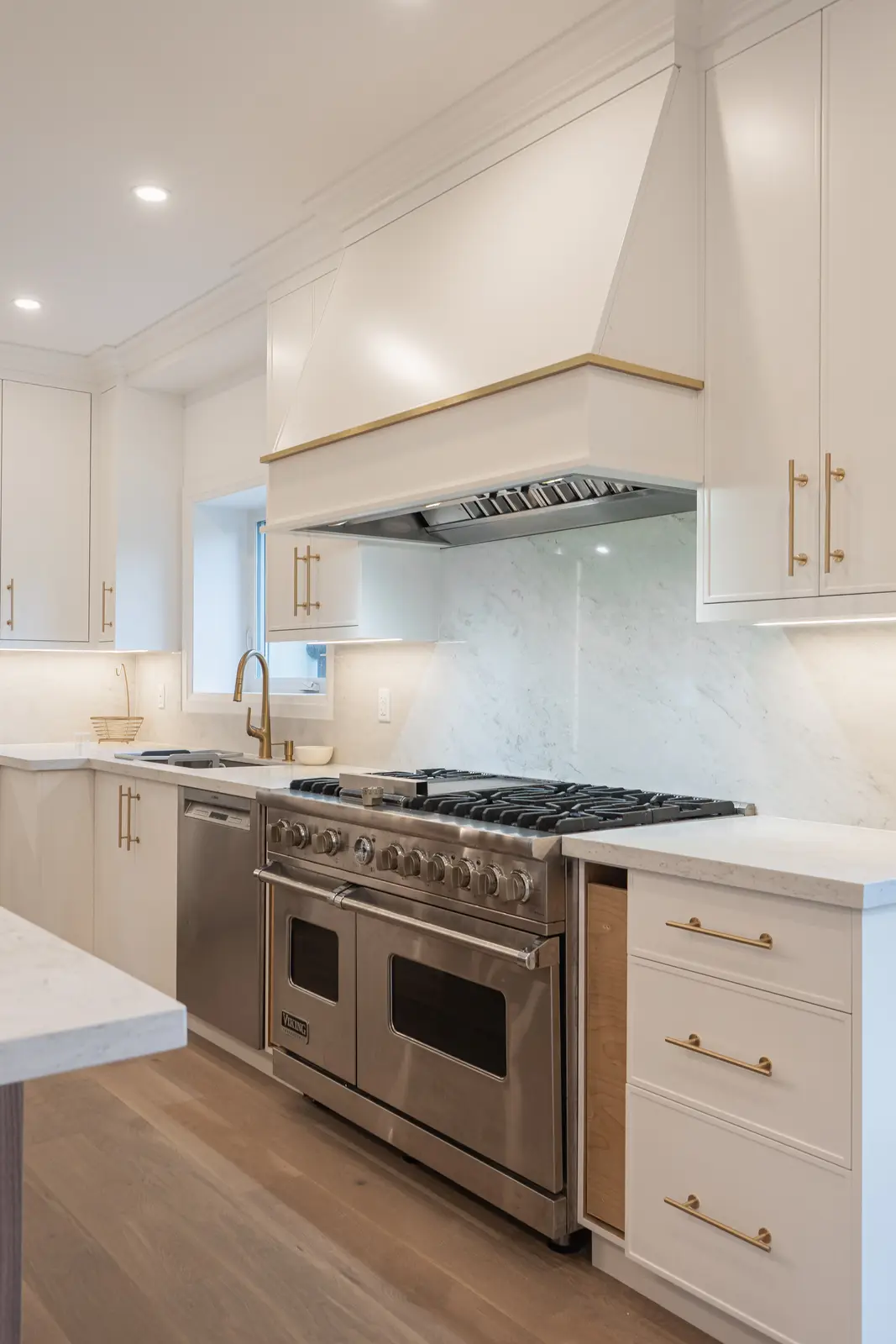 Room in a North York detached house renovation, with pale oak floors, white walls, and marble or warm wood millwork.