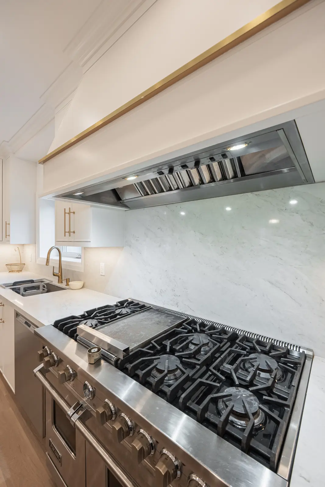 Room in a North York detached house renovation, with pale oak floors, white walls, and marble or warm wood millwork.