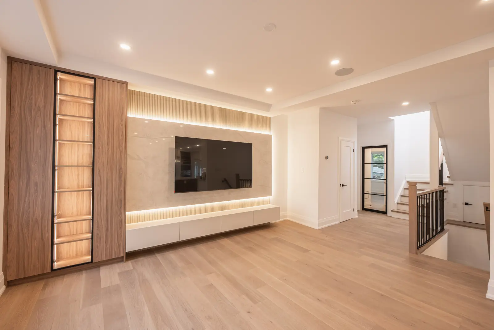 Room in a North York detached house renovation, with pale oak floors, white walls, and marble or warm wood millwork.