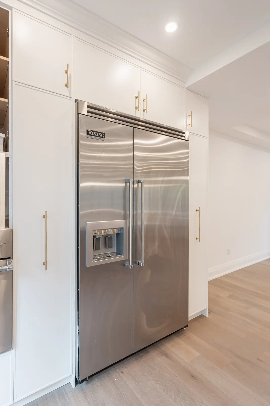 Room in a North York detached house renovation, with pale oak floors, white walls, and marble or warm wood millwork.