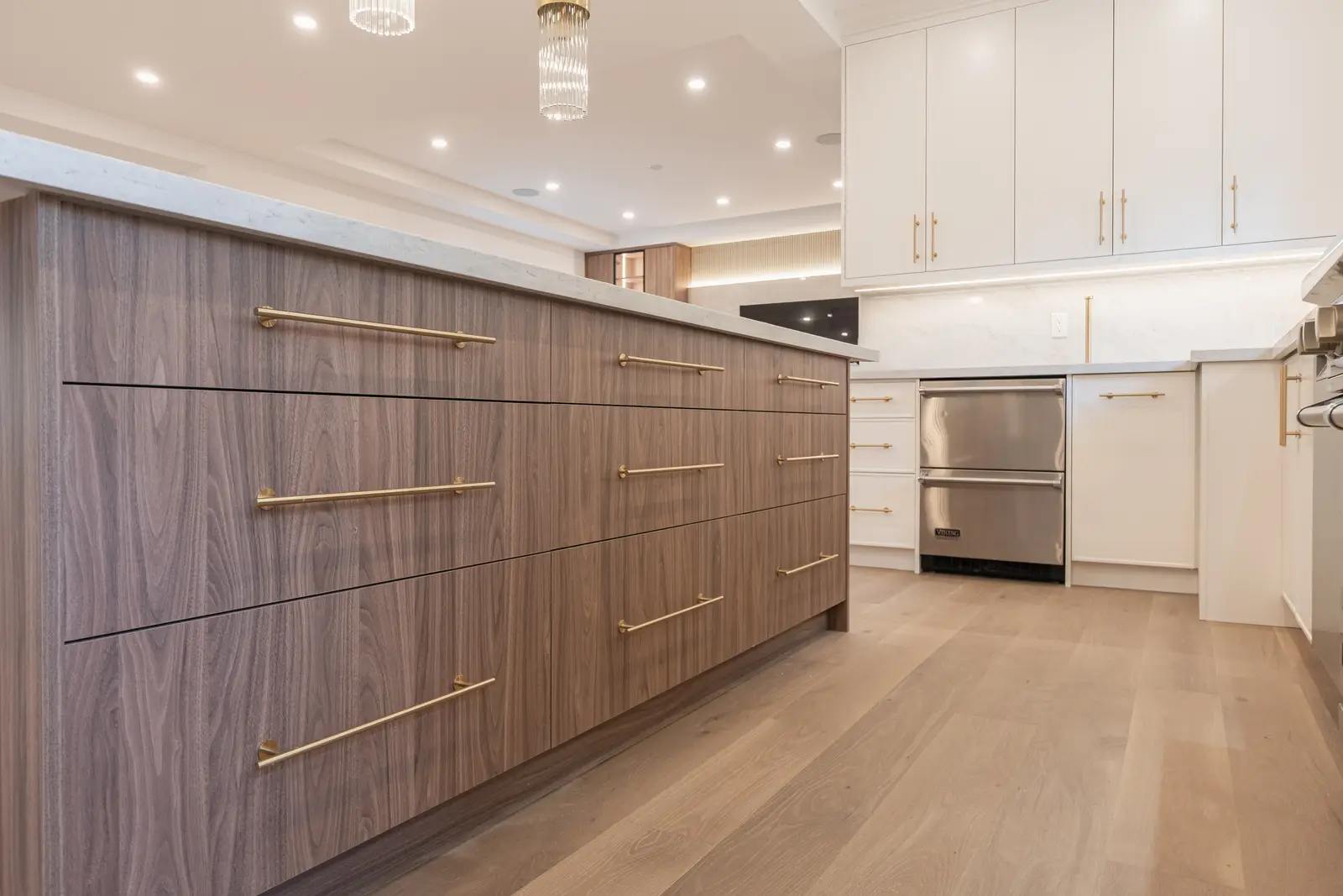 Room in a North York detached house renovation, with pale oak floors, white walls, and marble or warm wood millwork.