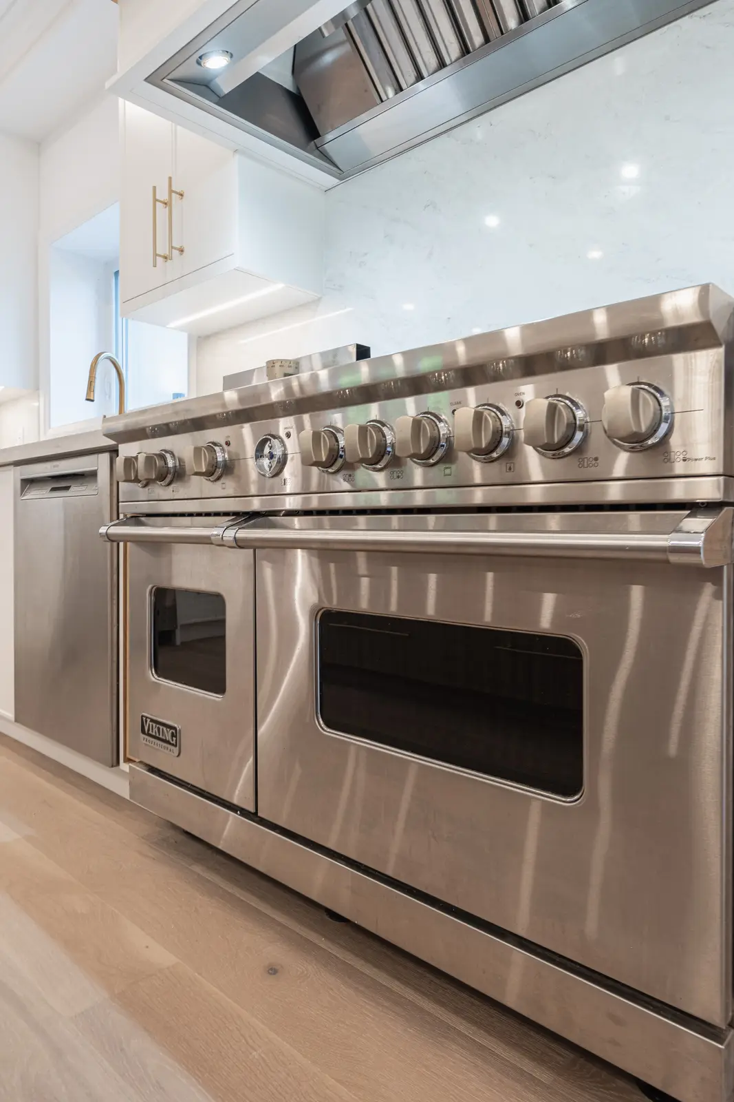 Room in a North York detached house renovation, with pale oak floors, white walls, and marble or warm wood millwork.