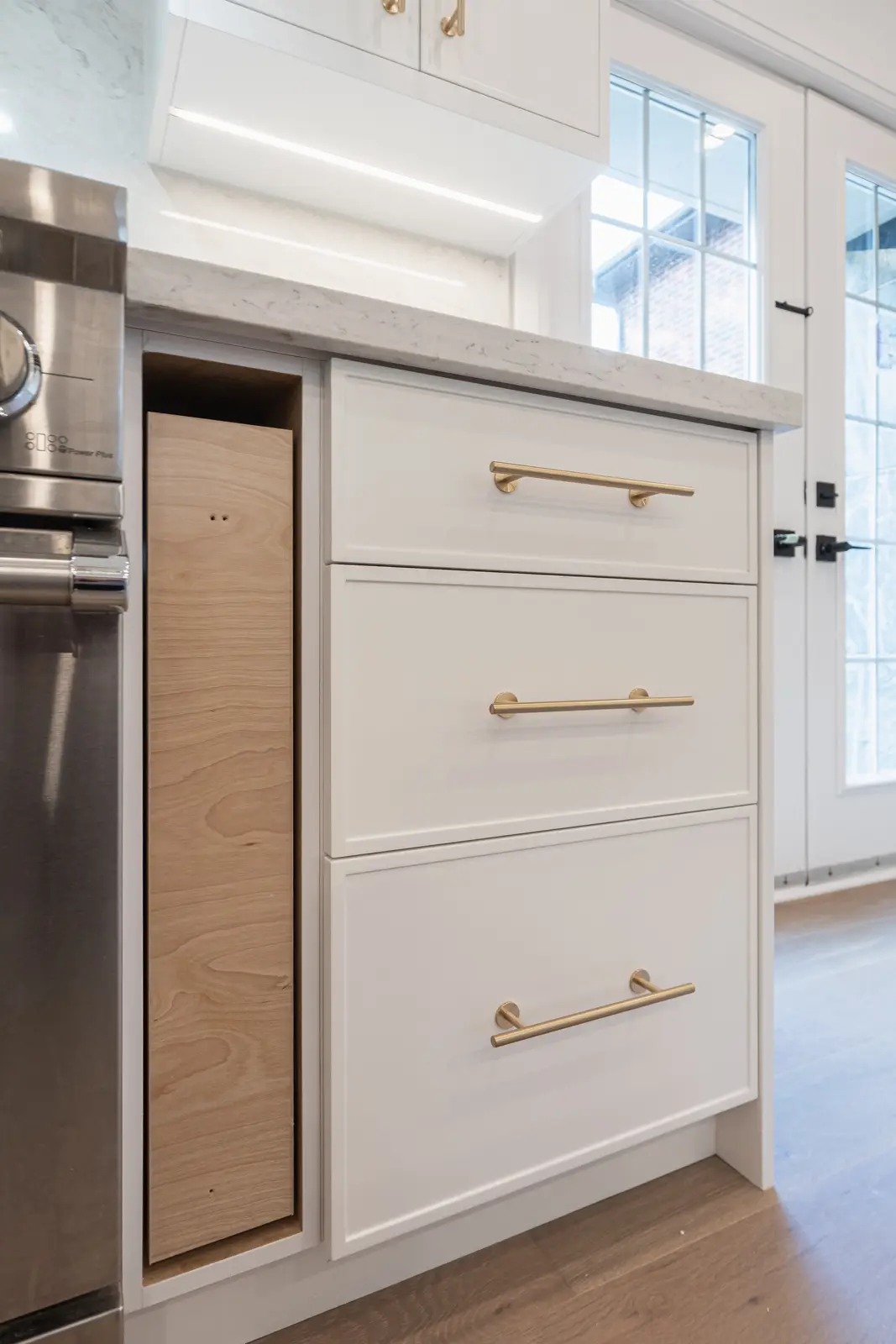 Room in a North York detached house renovation, with pale oak floors, white walls, and marble or warm wood millwork.