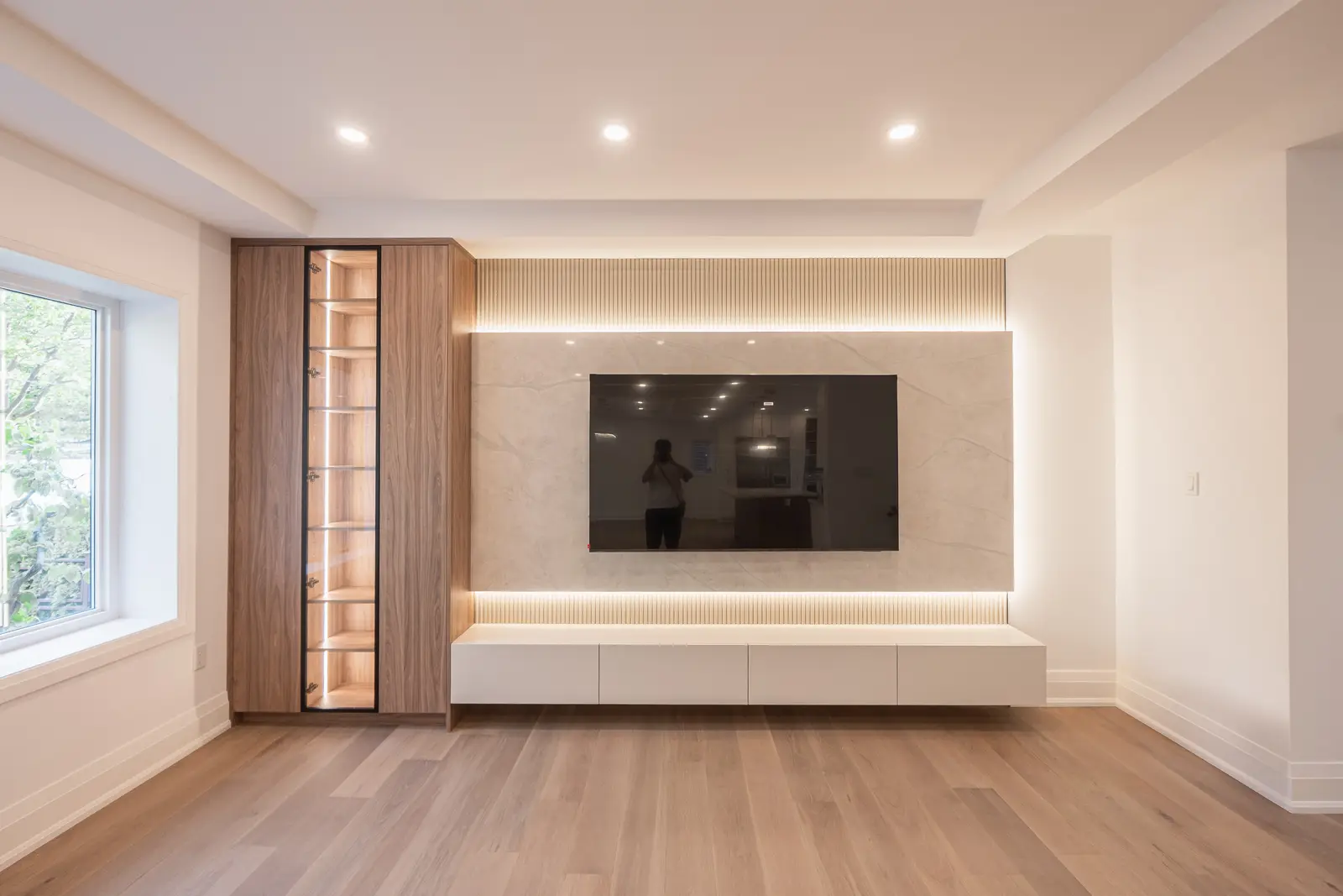 Room in a North York detached house renovation, with pale oak floors, white walls, and marble or warm wood millwork.