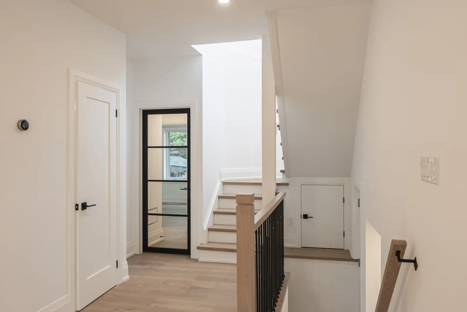 Room in a North York detached house renovation, with pale oak floors, white walls, and marble or warm wood millwork.