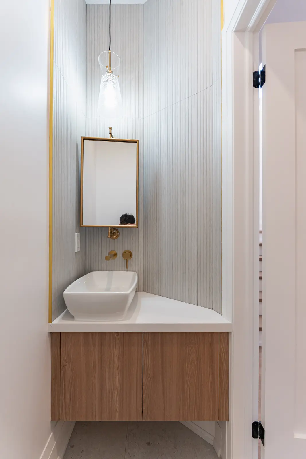Room in a North York detached house renovation, with pale oak floors, white walls, and marble or warm wood millwork.