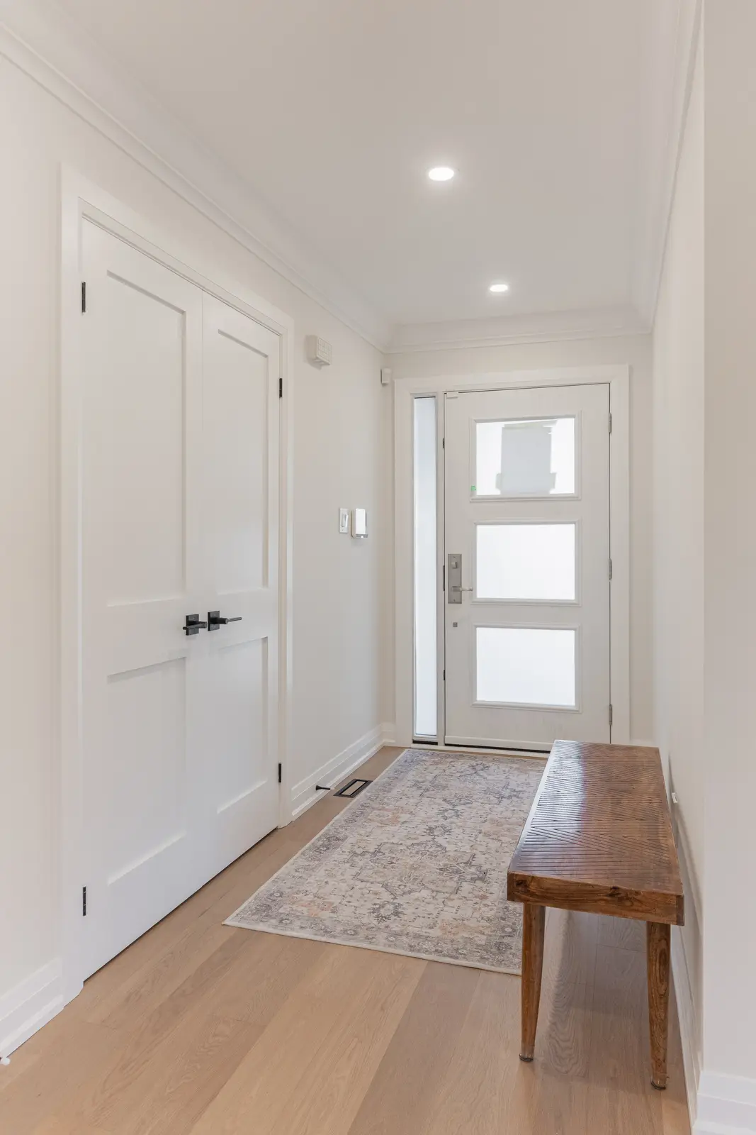 Interior of a Thornhill detached house renovation, with white cabinetry, light oak millwork, and a pale stone counter.